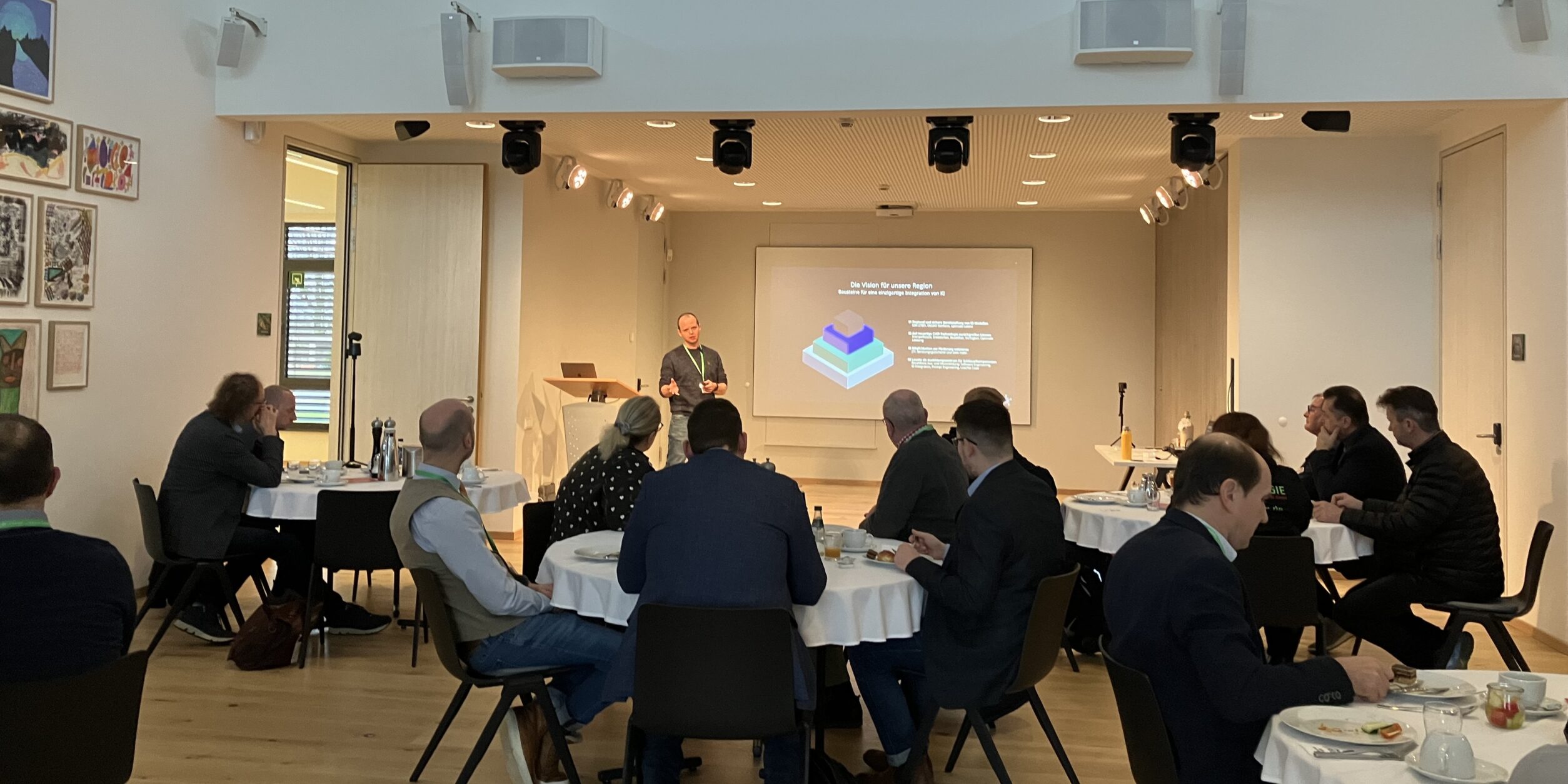 Menschen lauschen einem Vortrag bei einem Frühstück