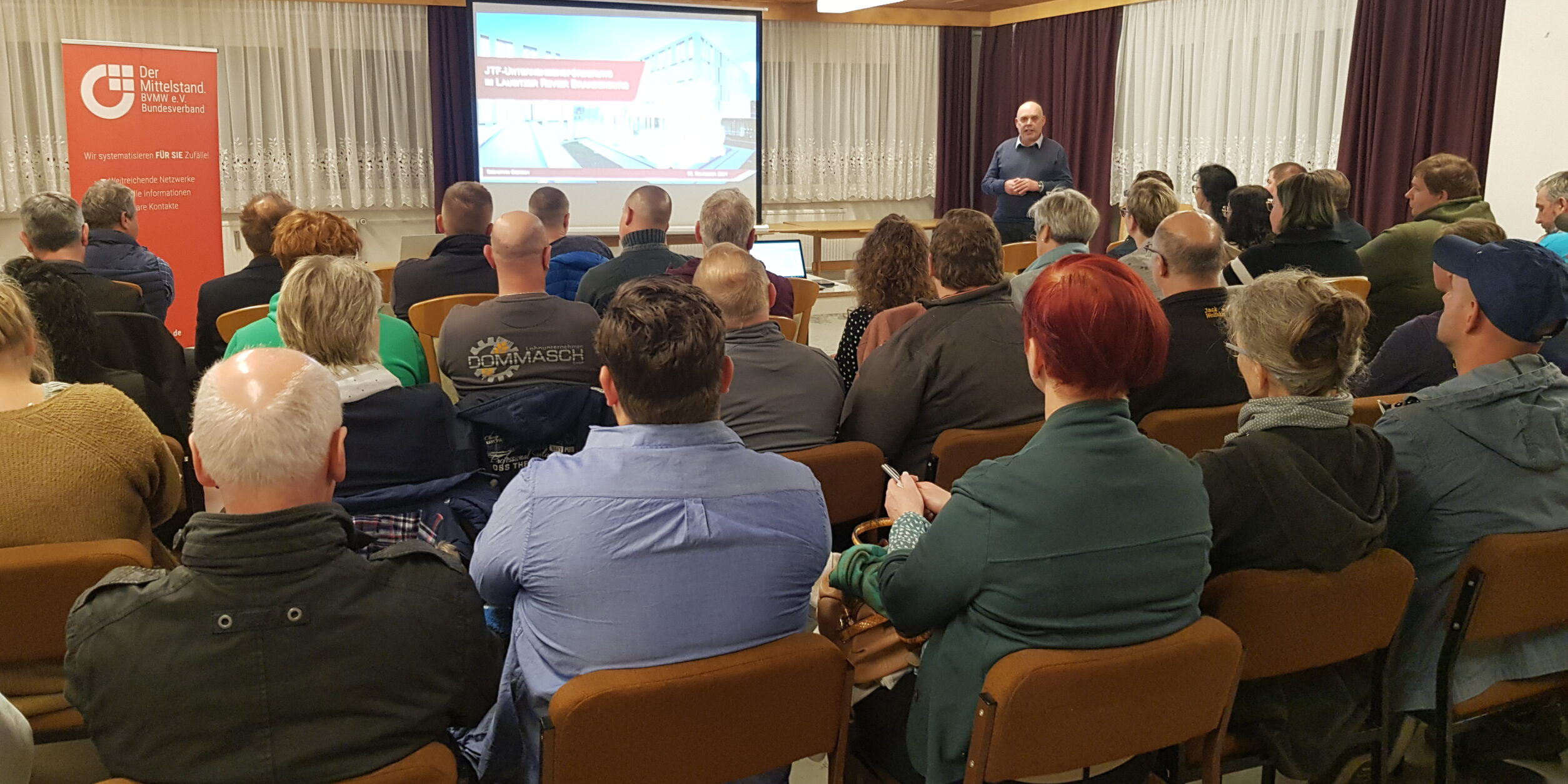 Unternehmer*innen lauschen einem Vortrag