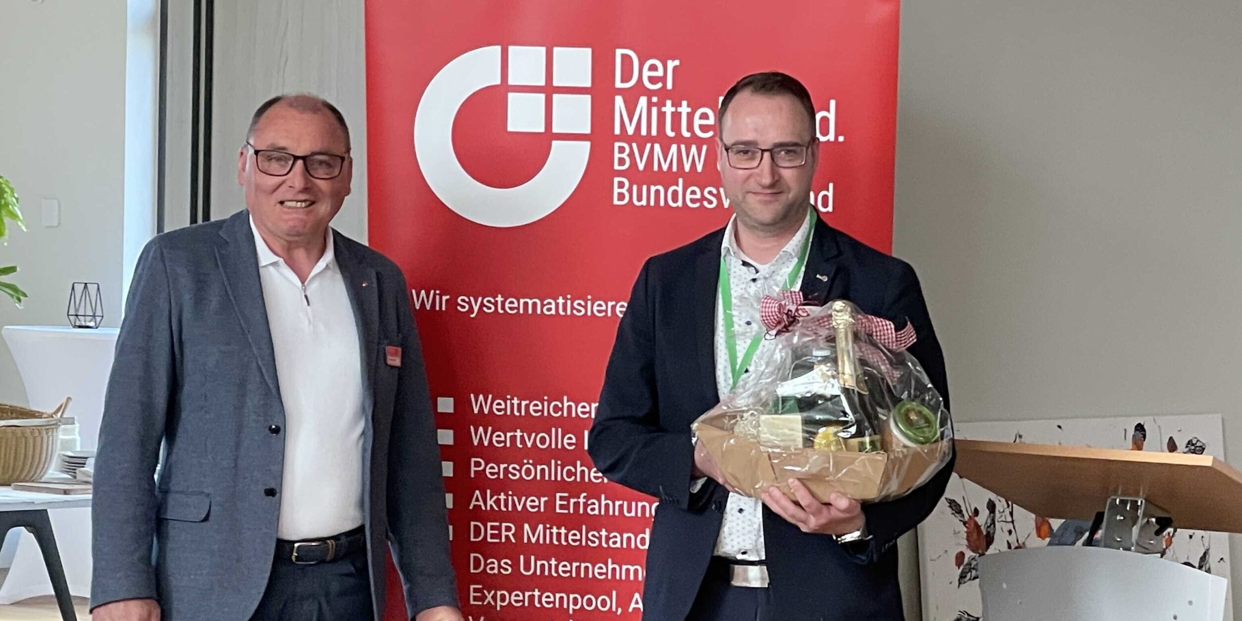 zwei Männer stehen vor einem Roll Up