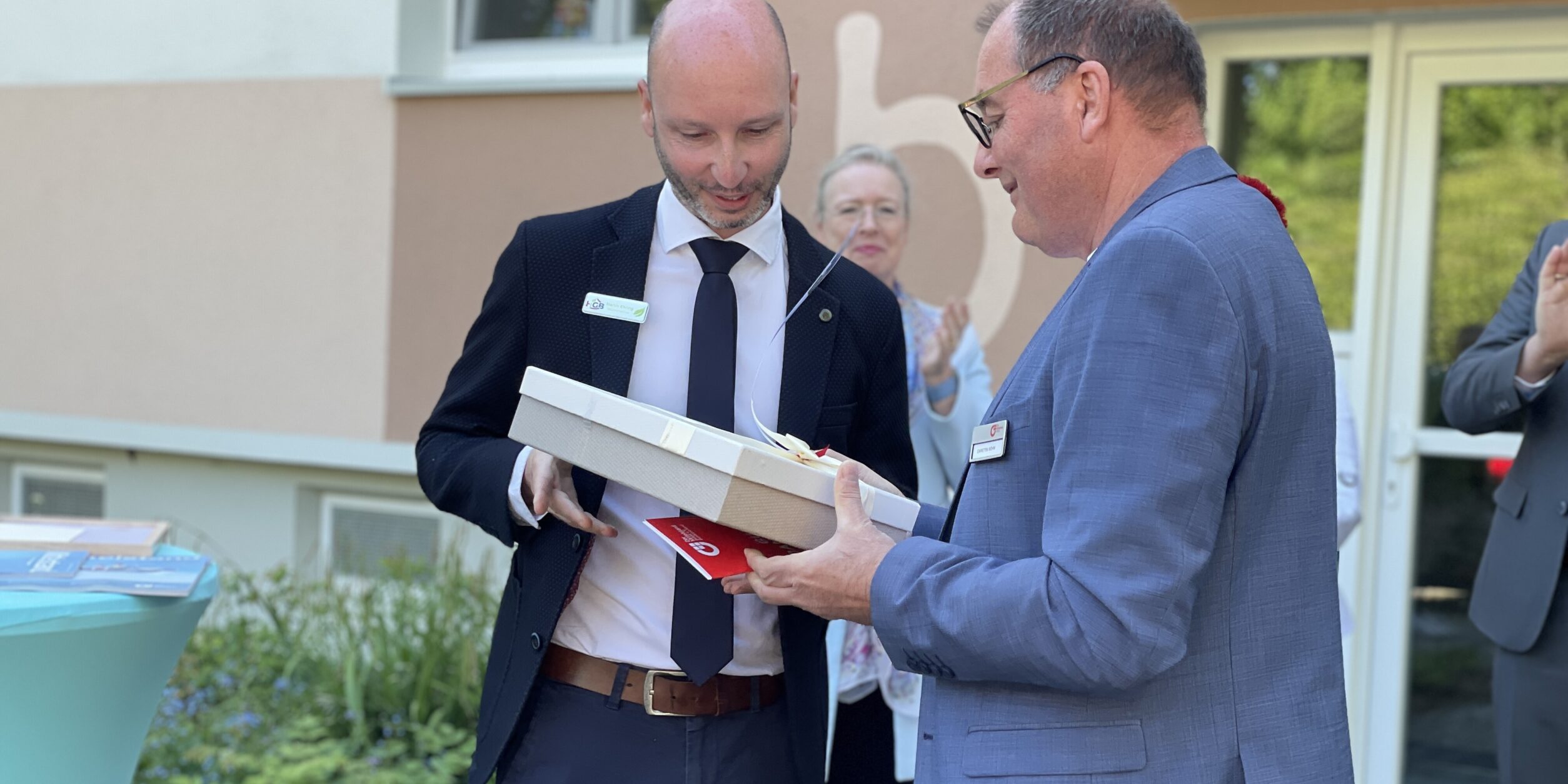 ein Mann überreicht einem weiteren Mann ein Präsent