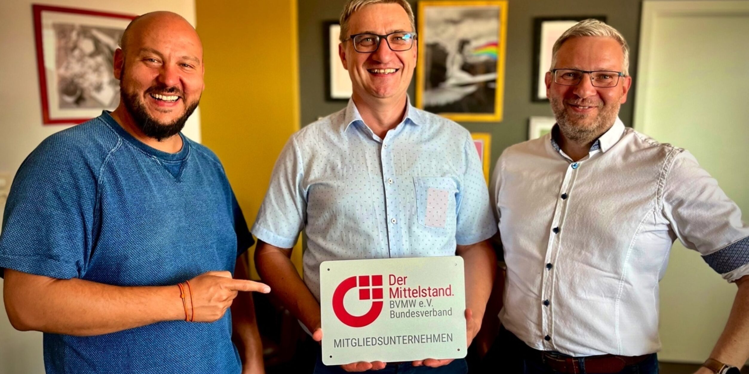 drei Männer halten ein Schild in die Höhe