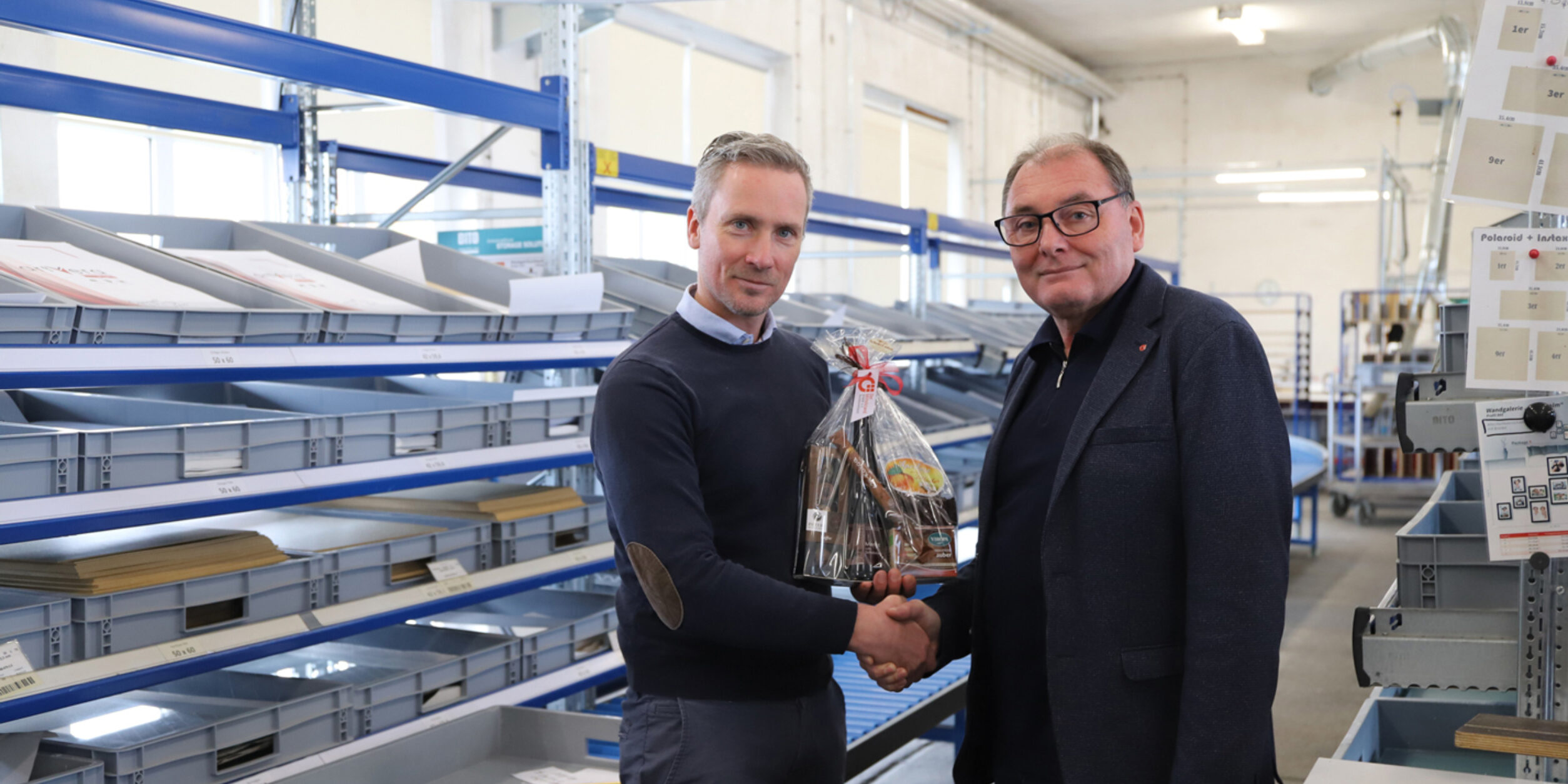 ein Mann gratuliert einem Unternehmer und überreicht ein Präsent