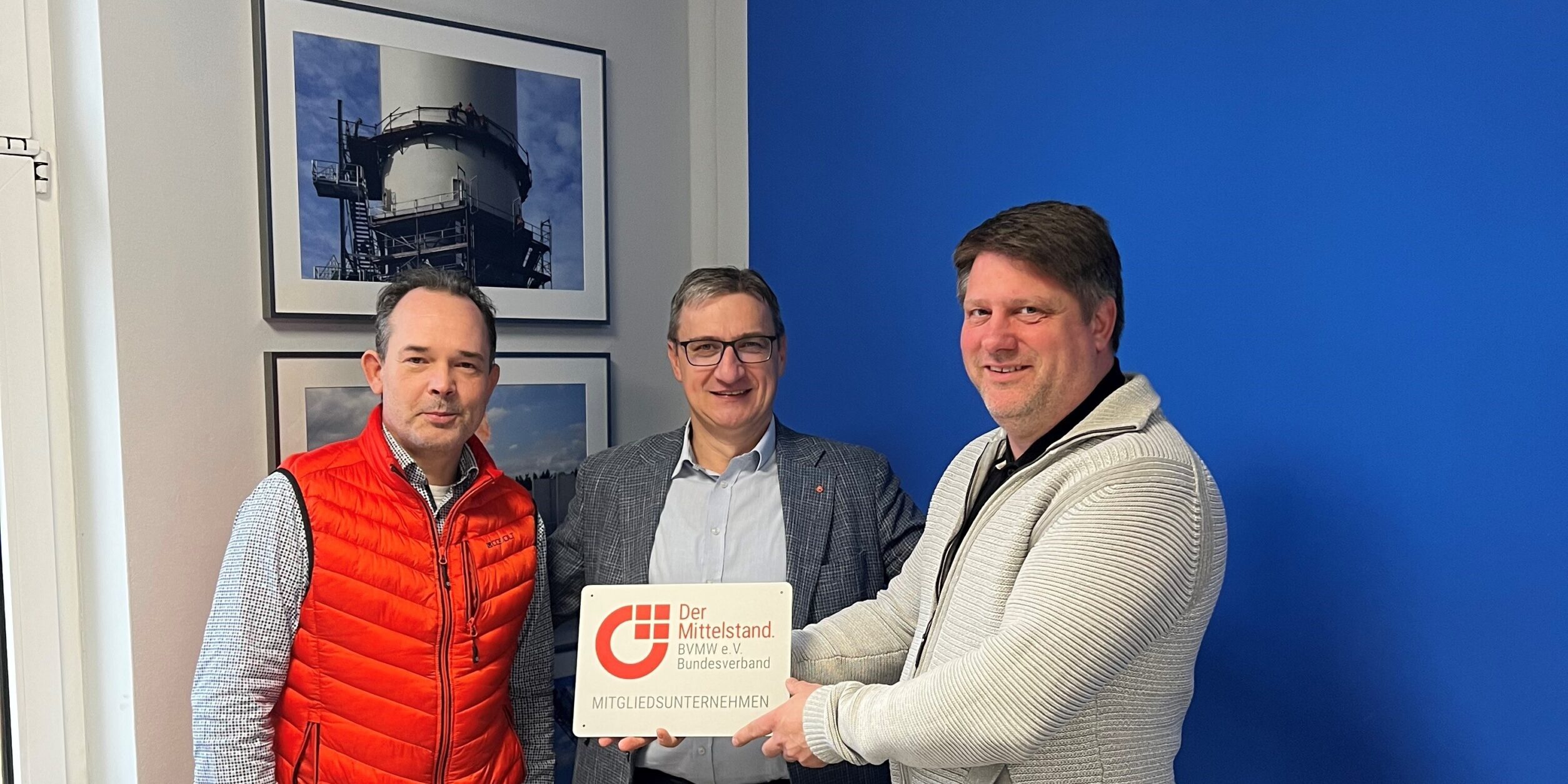 3 Personen halten das Mitgliedschild in die Höhe