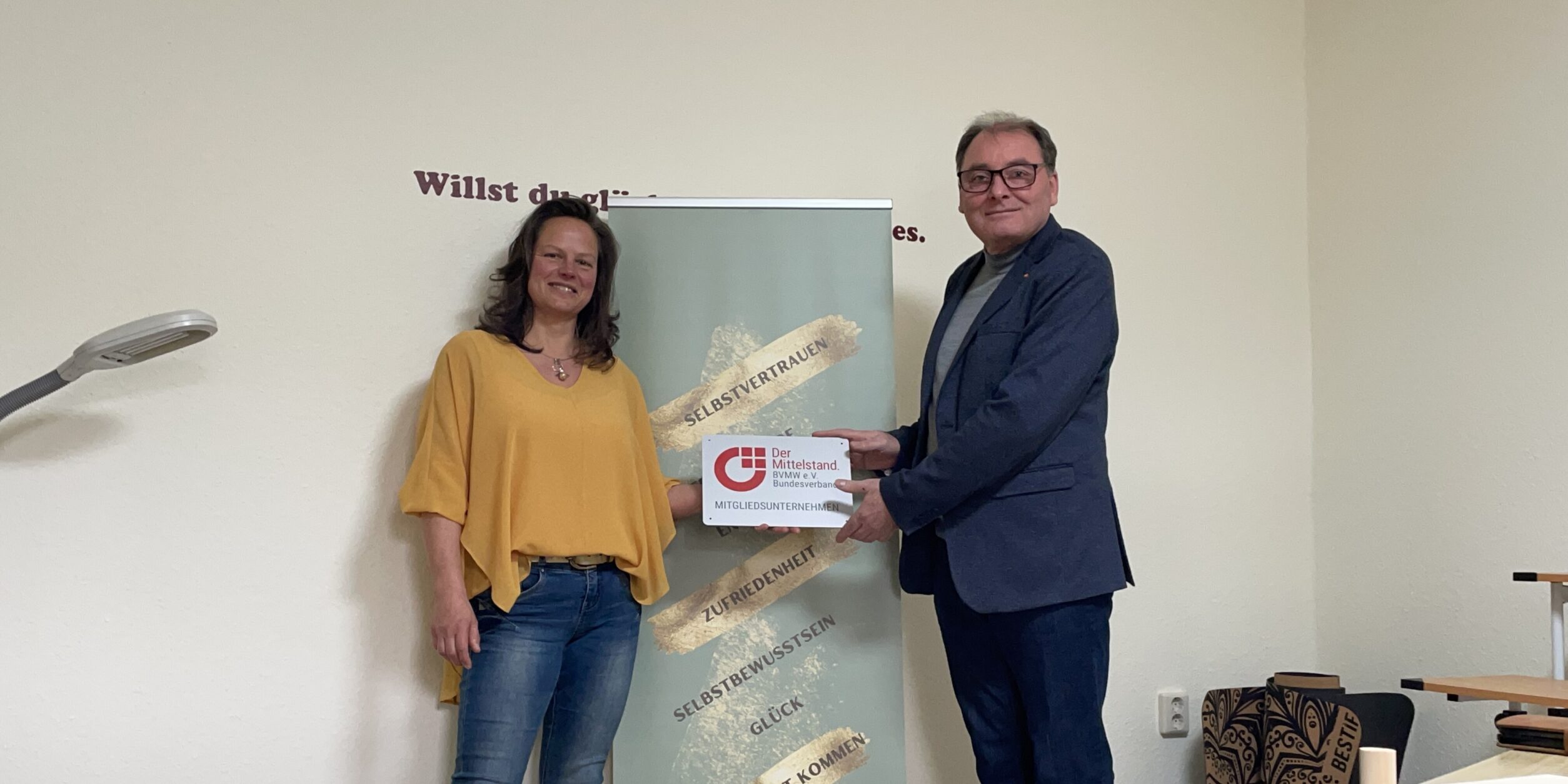 eine Frau und ein mann halten ein Schild in die Höhe