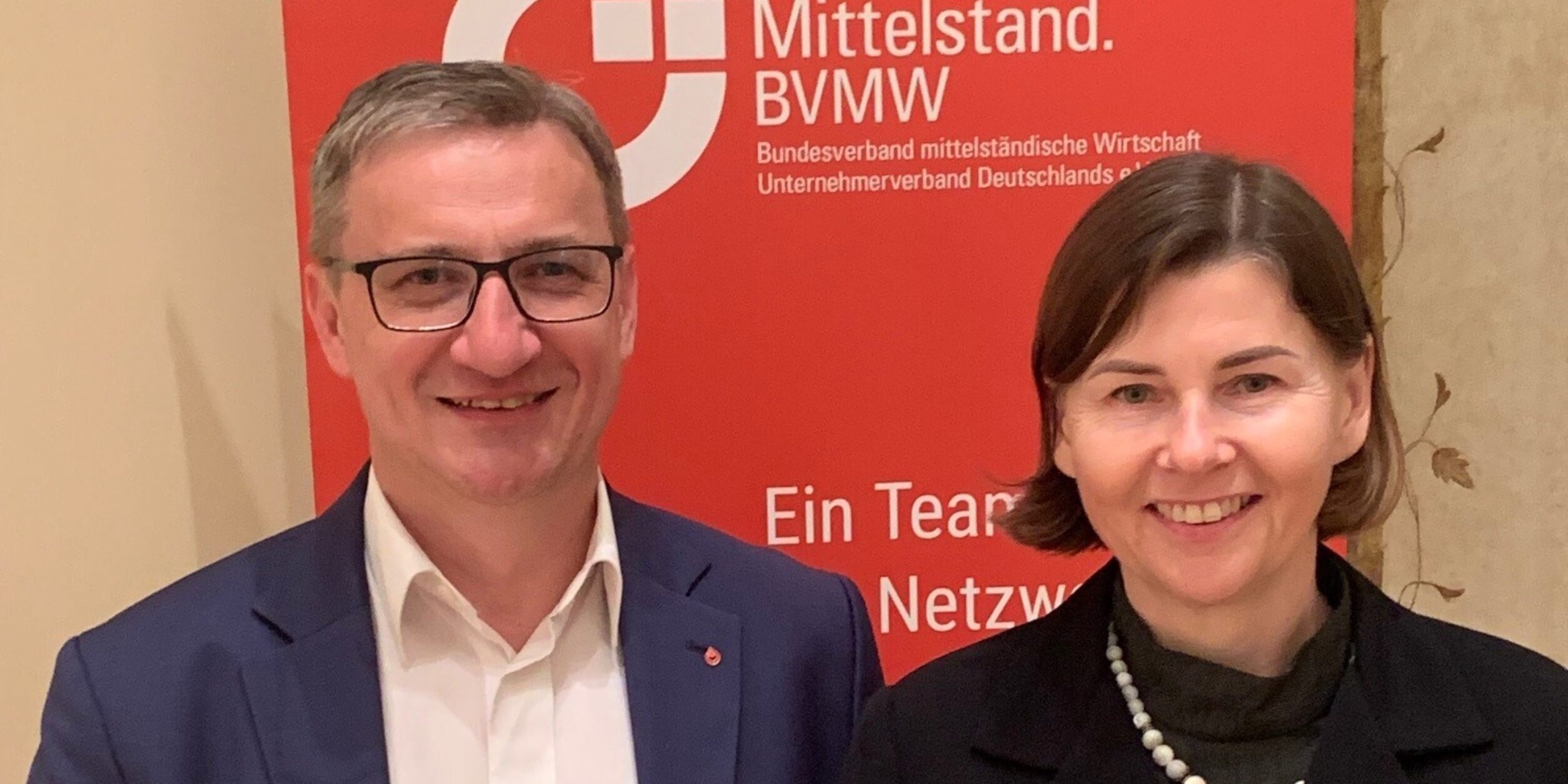 ein Mann und eine Frau stehen vor einem Plakat