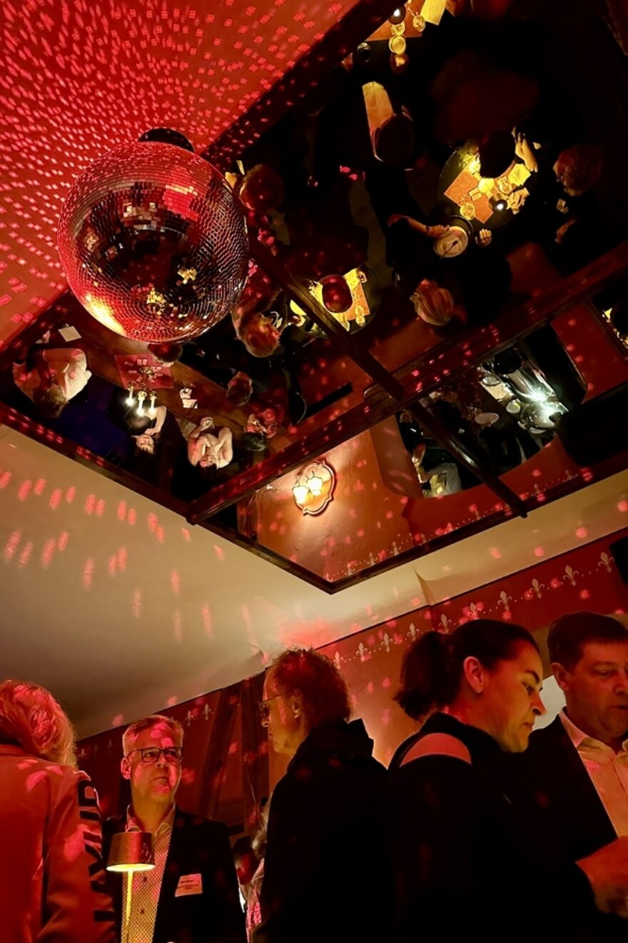 Menschen stehen unter einer Discokugel und unterhalten sich