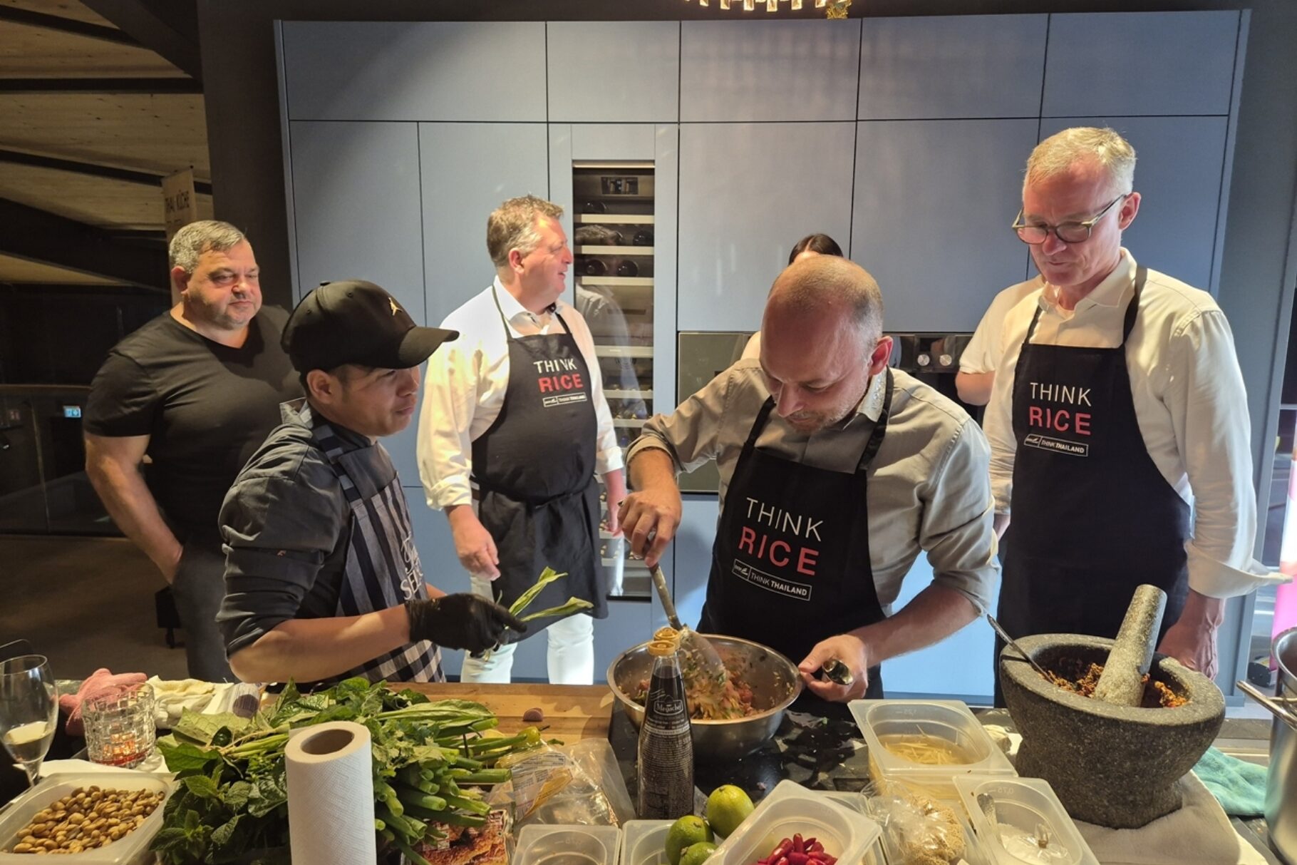 Teilnehmer der BVMW Veranstaltung "Thailändischer Abend" beim Kochen und Abschmecken.