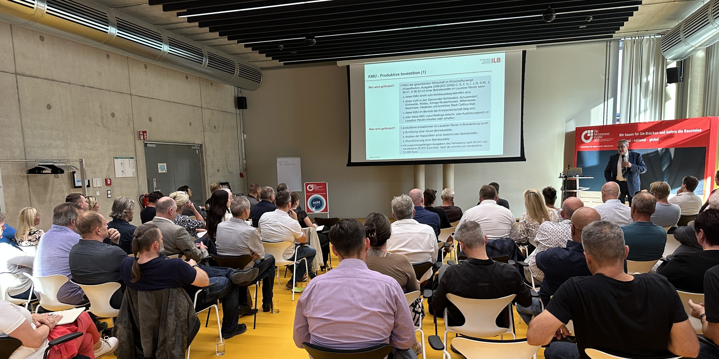 Unternehmer*innen lauschen einem Vortrag über Fördermöglichkeiten