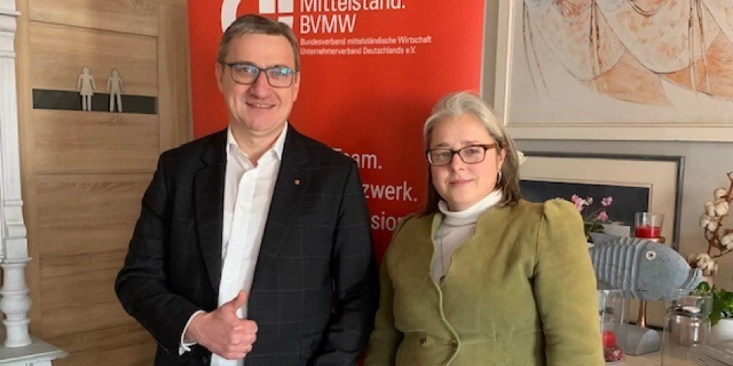 ein Mann und eine Frau Stehen vor einem Rollup