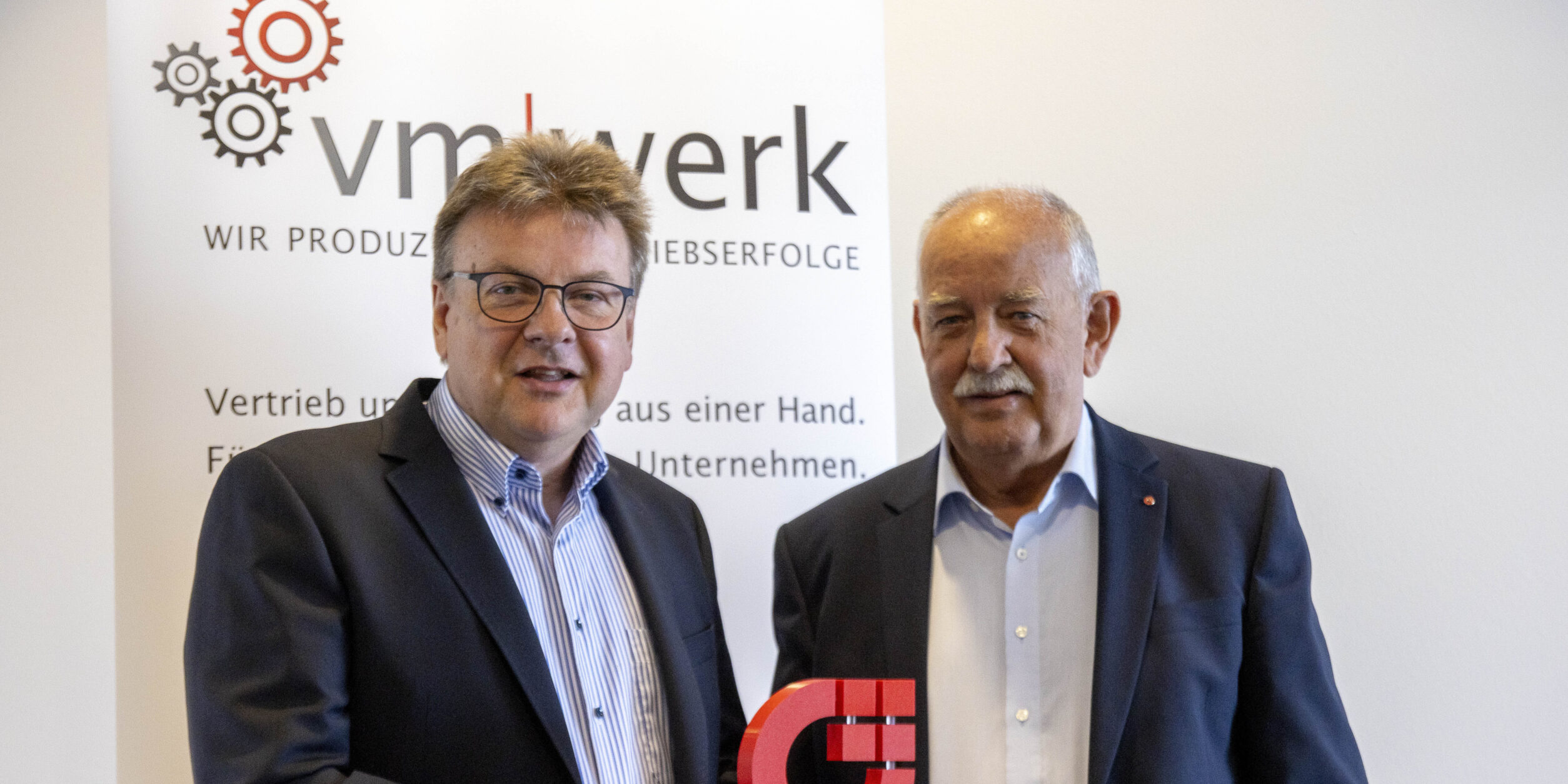 Wolfgang Paltinat und Detlef Blome vor einem VM-Werk-Banner