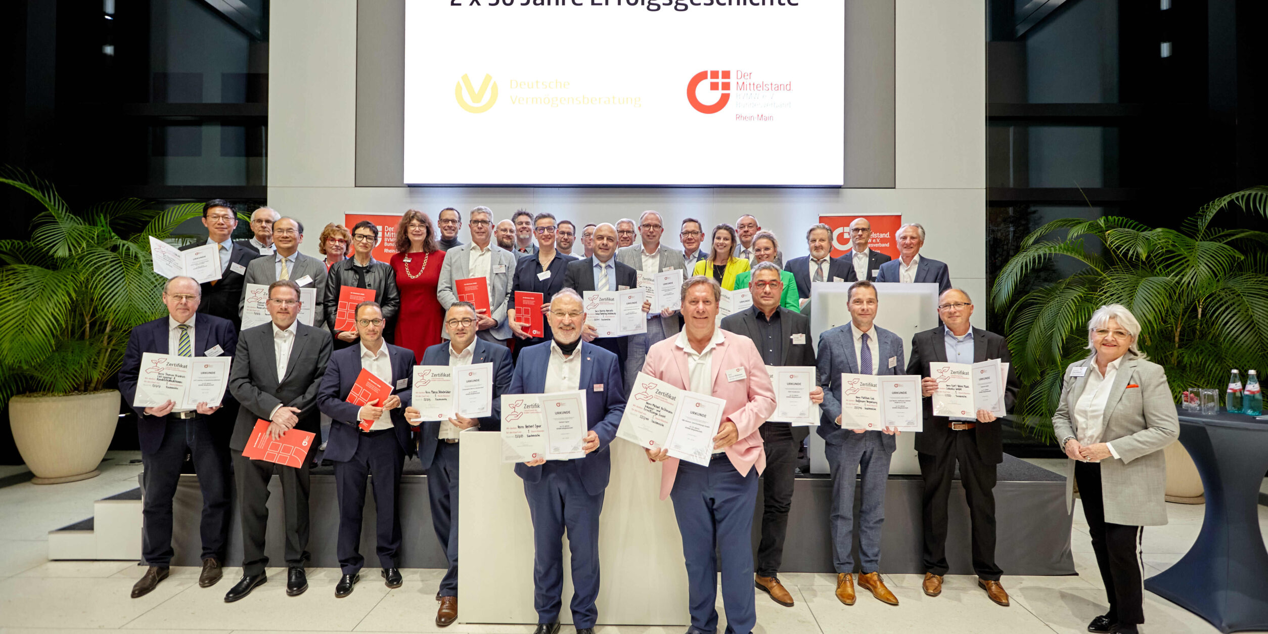 30 Jubilare zeigen stolz ihre Urkunden.