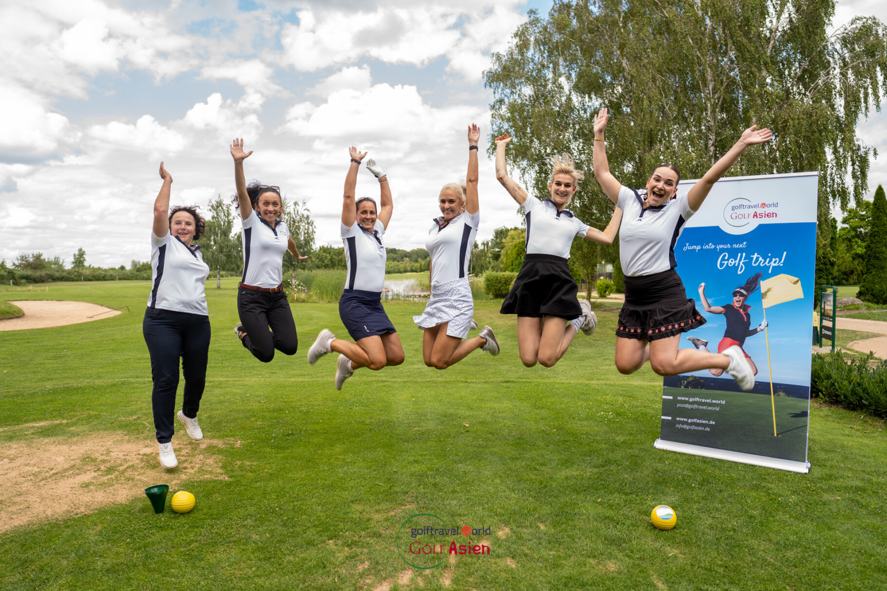 sechs Frauen im Golfoutfit springen hoch auf einem Golfplatz