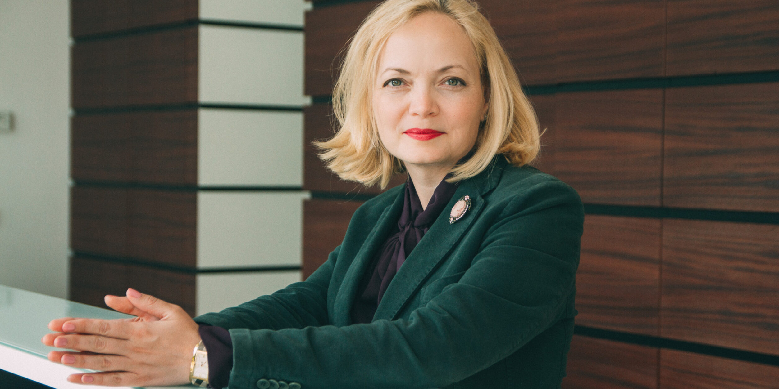 Eine blonde Frau in einem grünen Blazer