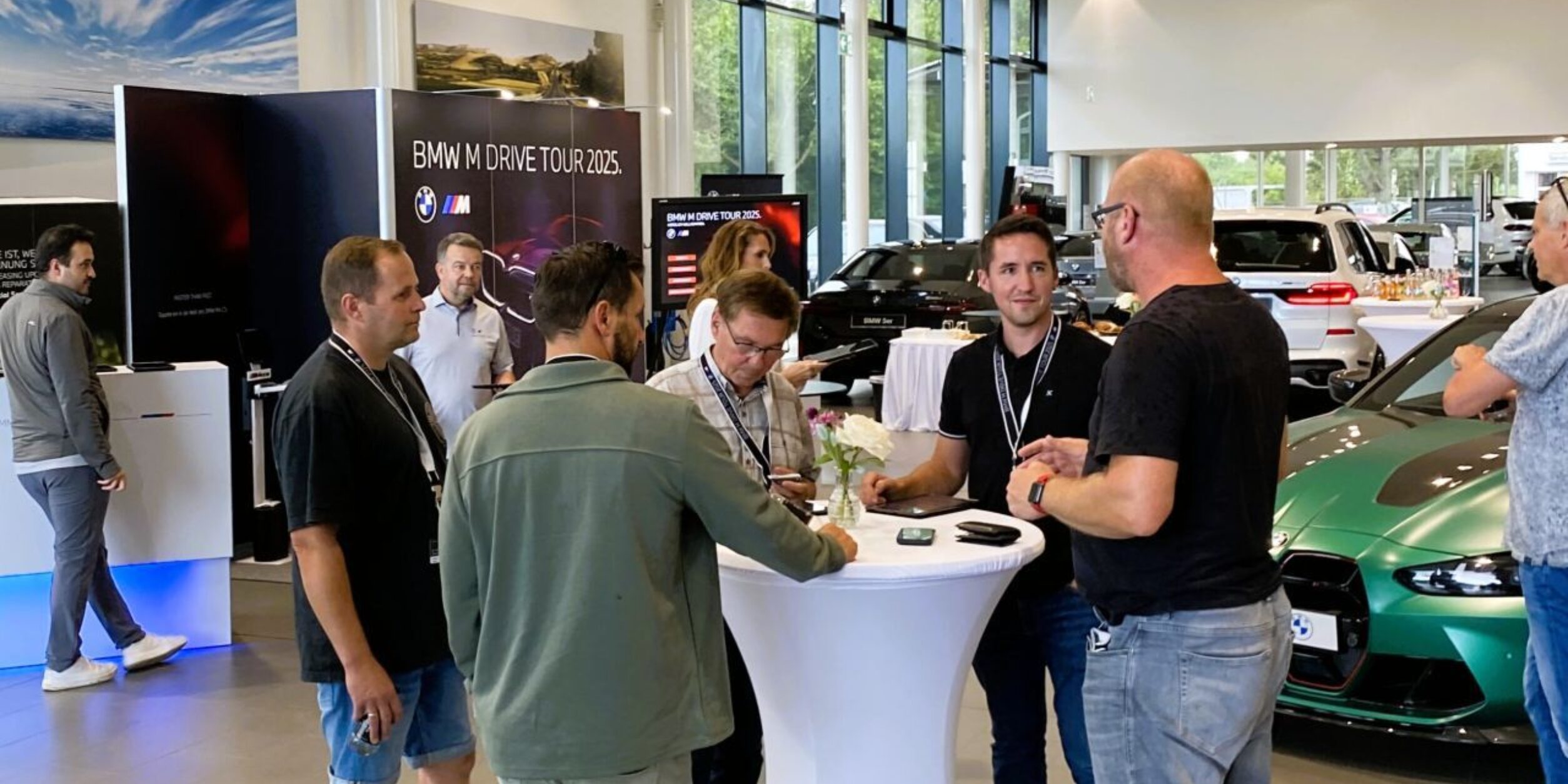 Leute stehen während einer Veranstaltung an einem Stehtisch