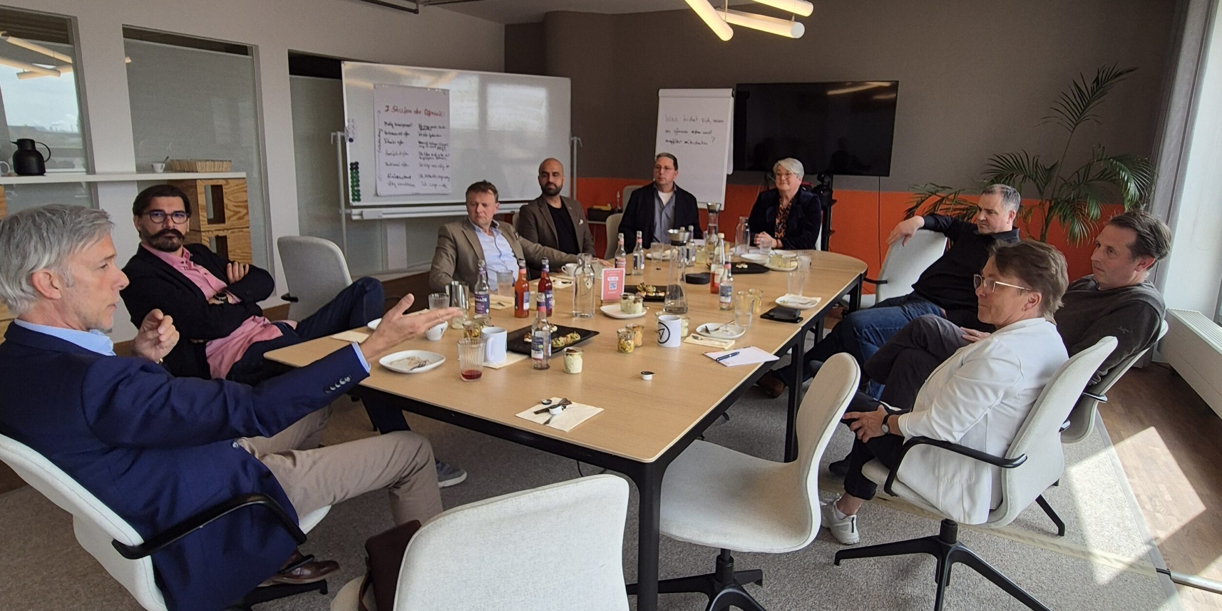 Unternehmer:innen sitzen an einem Besprechungstisch