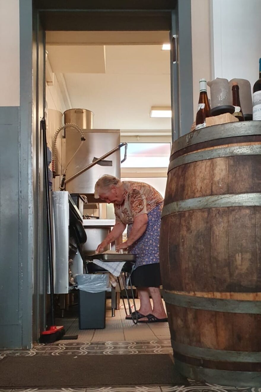 eine ältere Italienerin, die in der Küche eines Restaurants Pastateig knetet