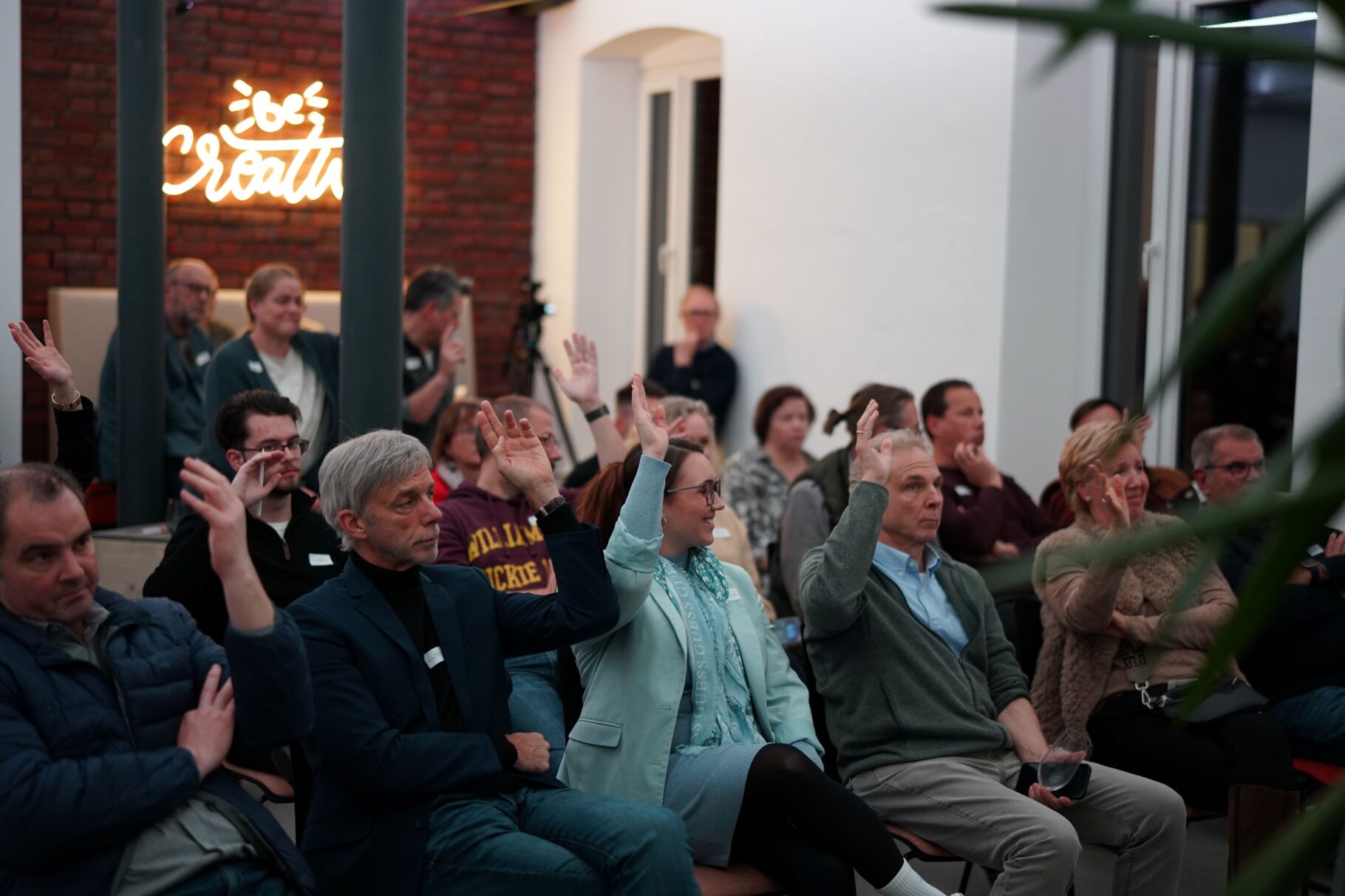 Publikum das eine Hand hebt um abzustimmen