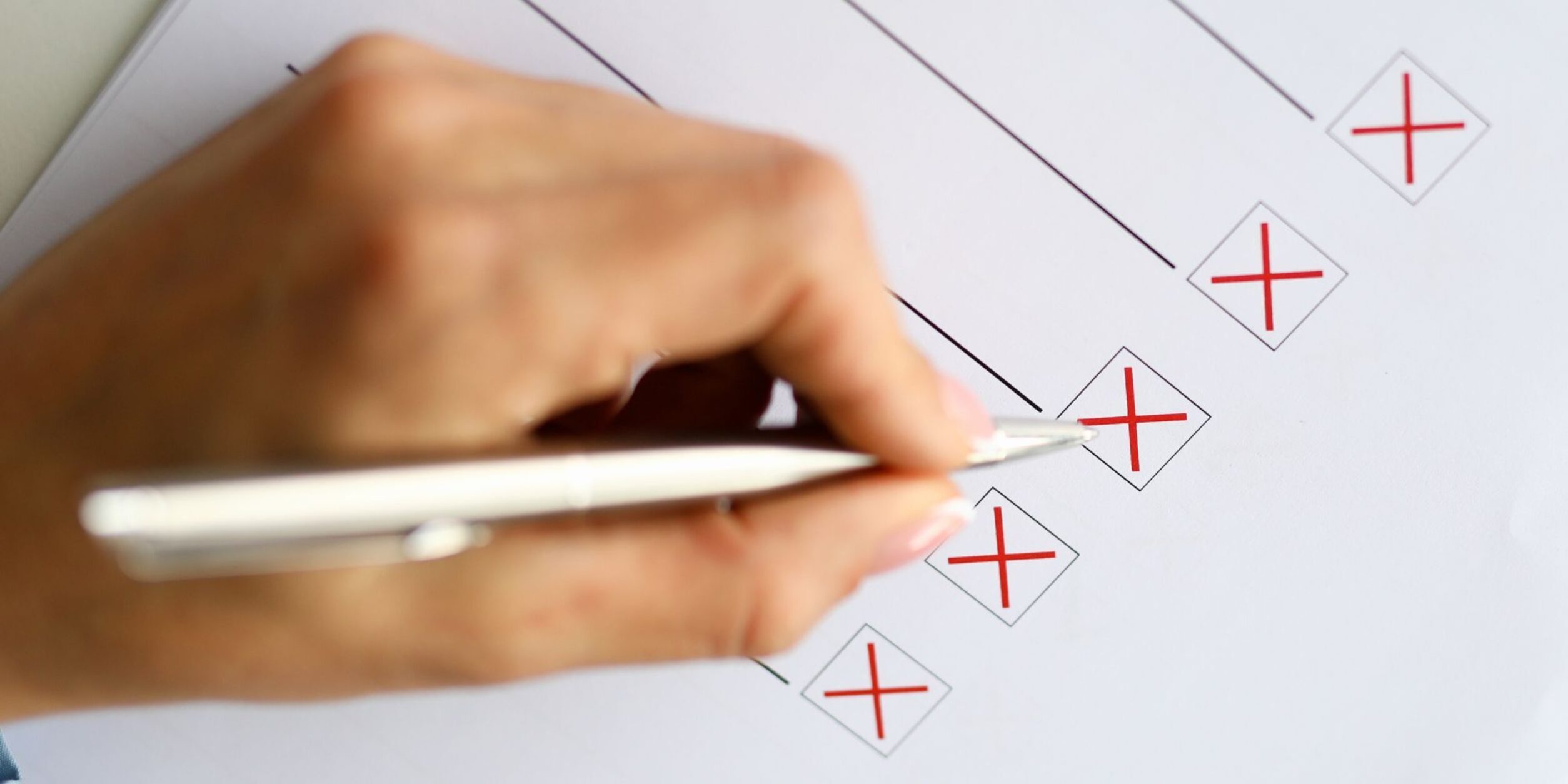 Hand mit Stift kreuzt Auswahl an