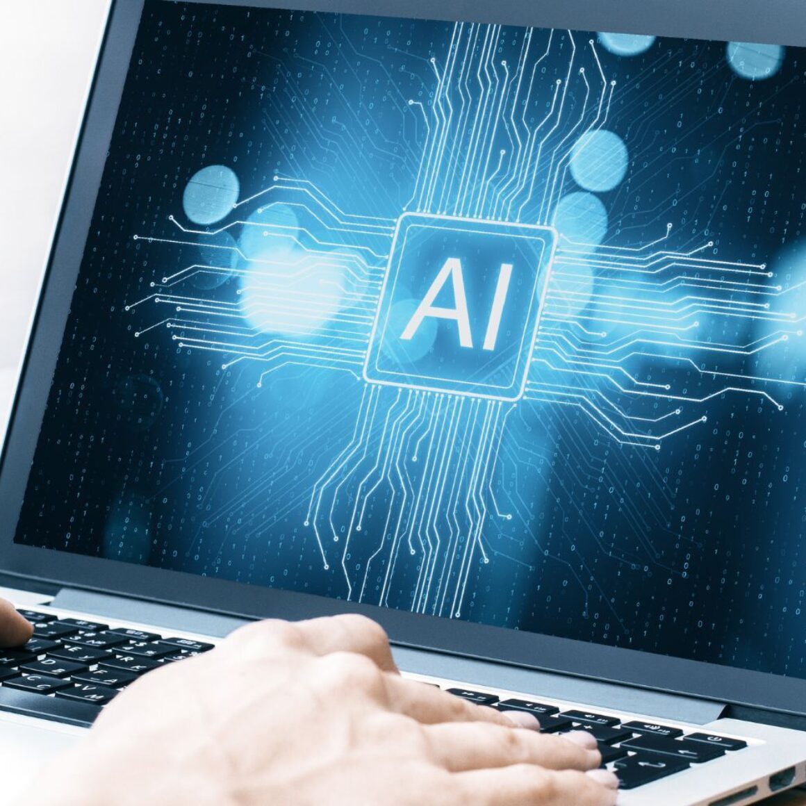 Laptop, Hände auf Tastatur, Schrift "AI" auf dem Bildschirm