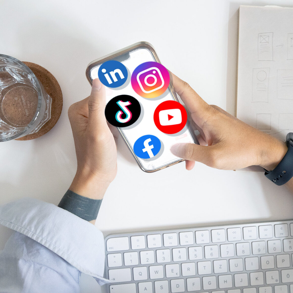 Icons und Logos von Social Media Plattformen auf einem Handy am Arbeitsplatz