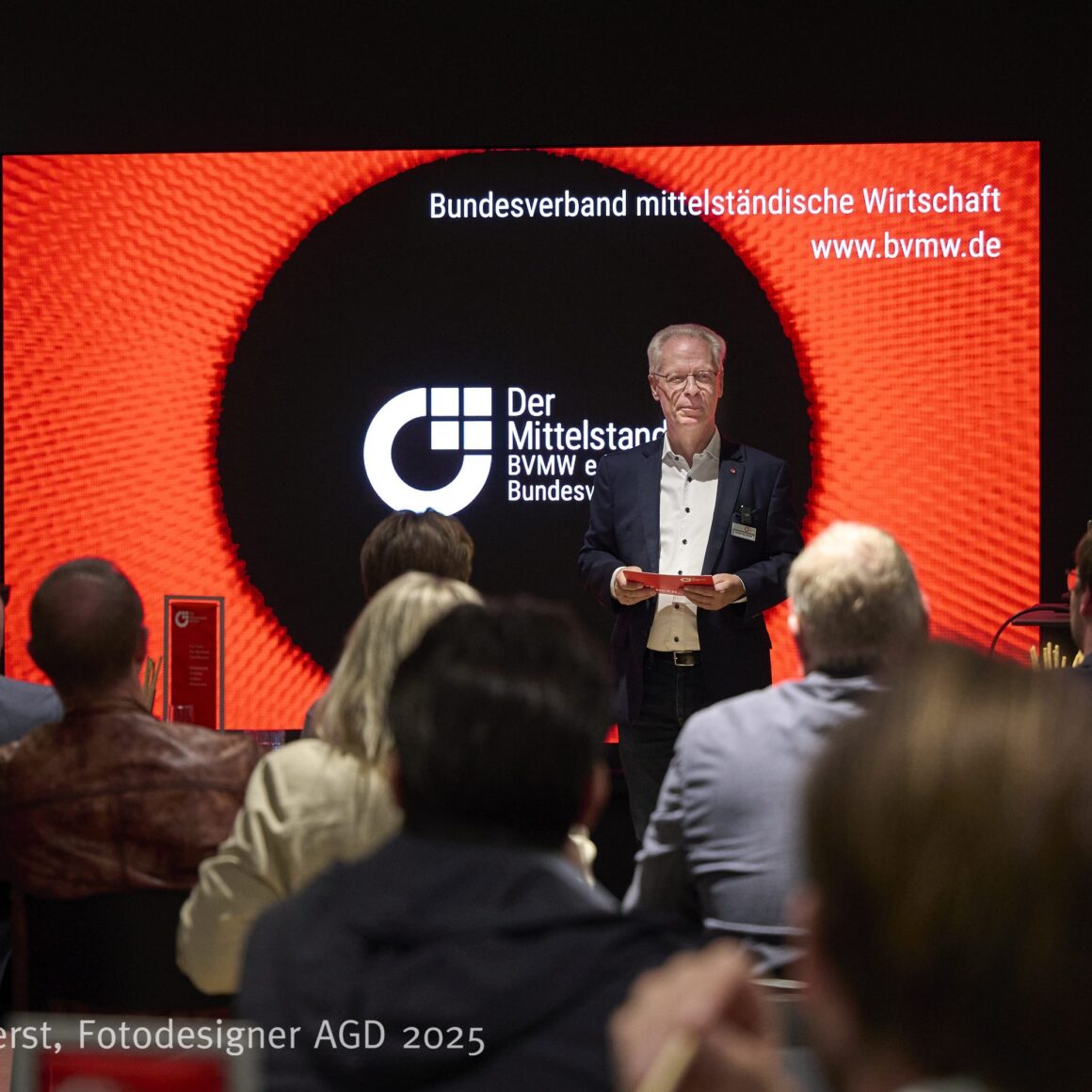 Blick der Teilnehmer auf die Bühne während der Begrüßung durch Lothar Schmidt