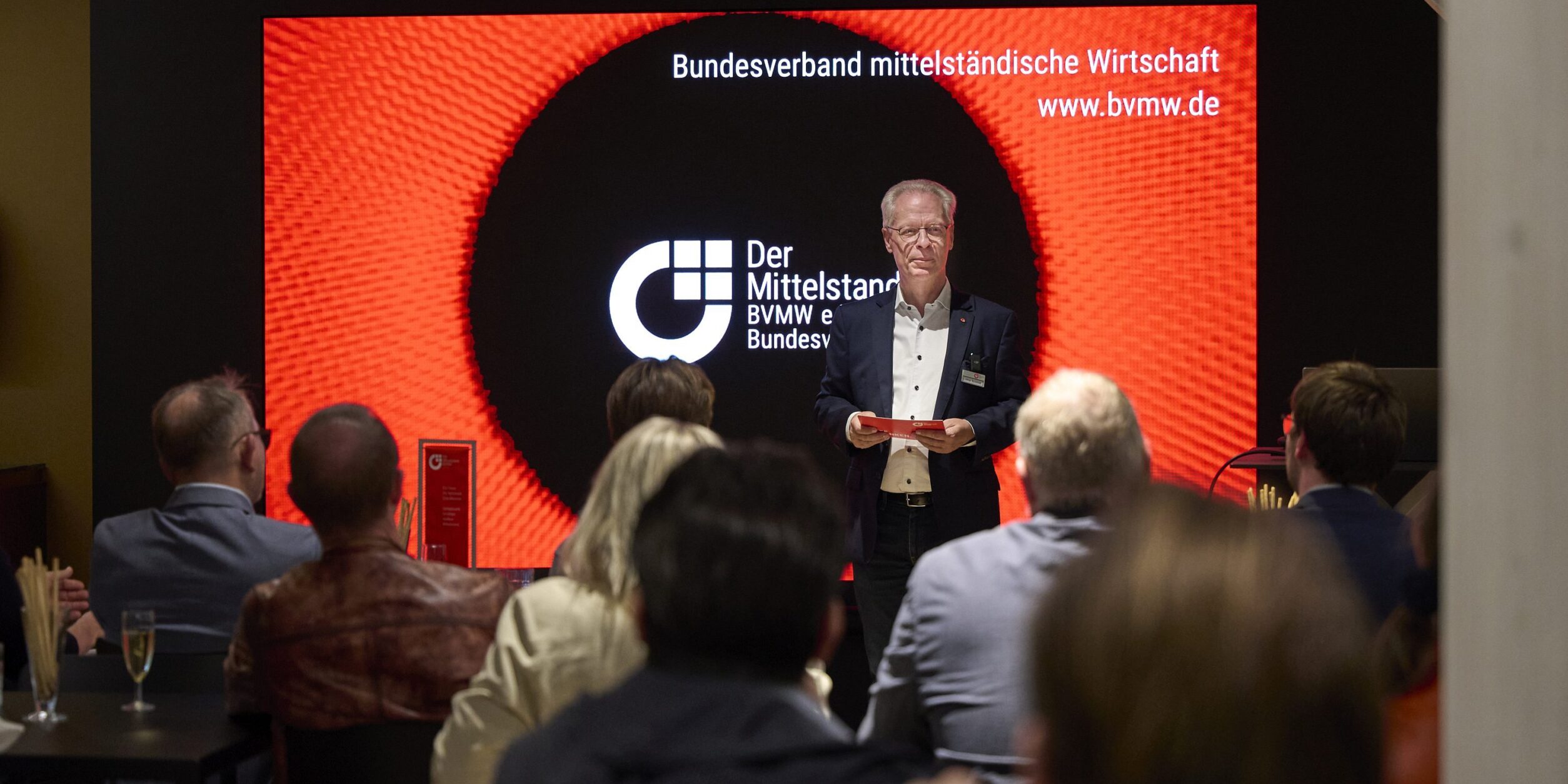 Blick der Teilnehmer auf die Bühne während der Begrüßung durch Lothar Schmidt