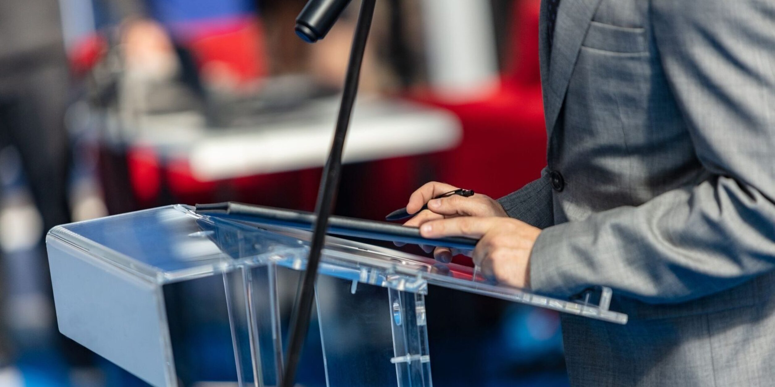 Sprecher am Podium mit Mikrofon