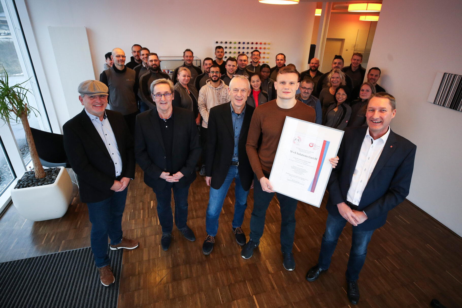 Klaus Zeiler (von links, Leiter der BVMW-Wirtschaftsregion Schwarzwald-Bodensee), Auditor Hugo Frey, die Geschäftsführer Ulrich und Jonathan Wernz sowie Volker Goerz (Leiter des BVMW-Kreisverband Rottweil und Schwarzwald-Baar-Kreis) freuen sich mit den Mitarbeitern über das silberne Siegel „Attraktiver Arbeitgeber“ für W+S Solutions. Foto: BVMW