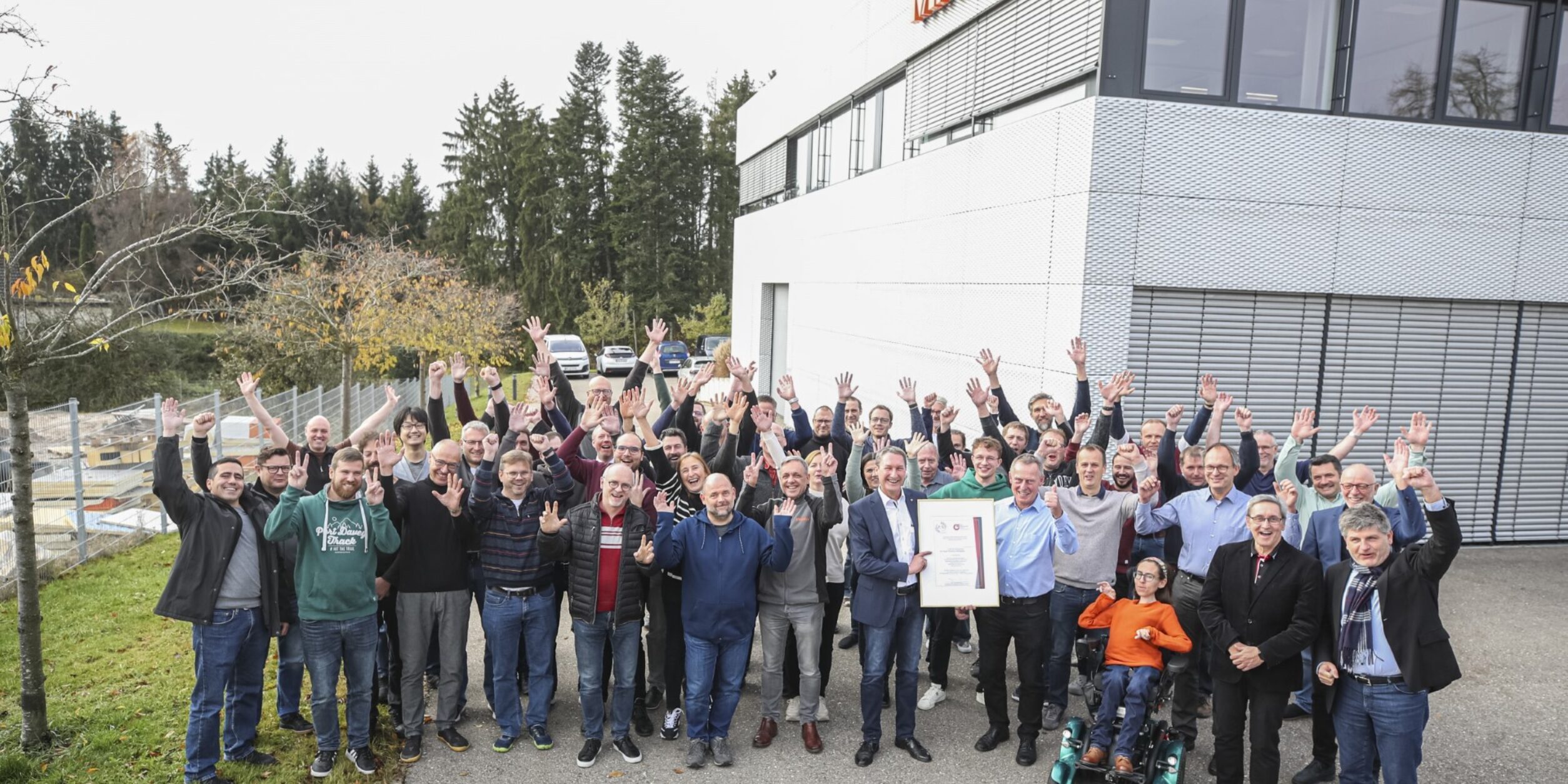 Die Belegschaft von Mitutoyo freut sich bei der Siegelübergabe über die goldwürdigen Ergebnisse.