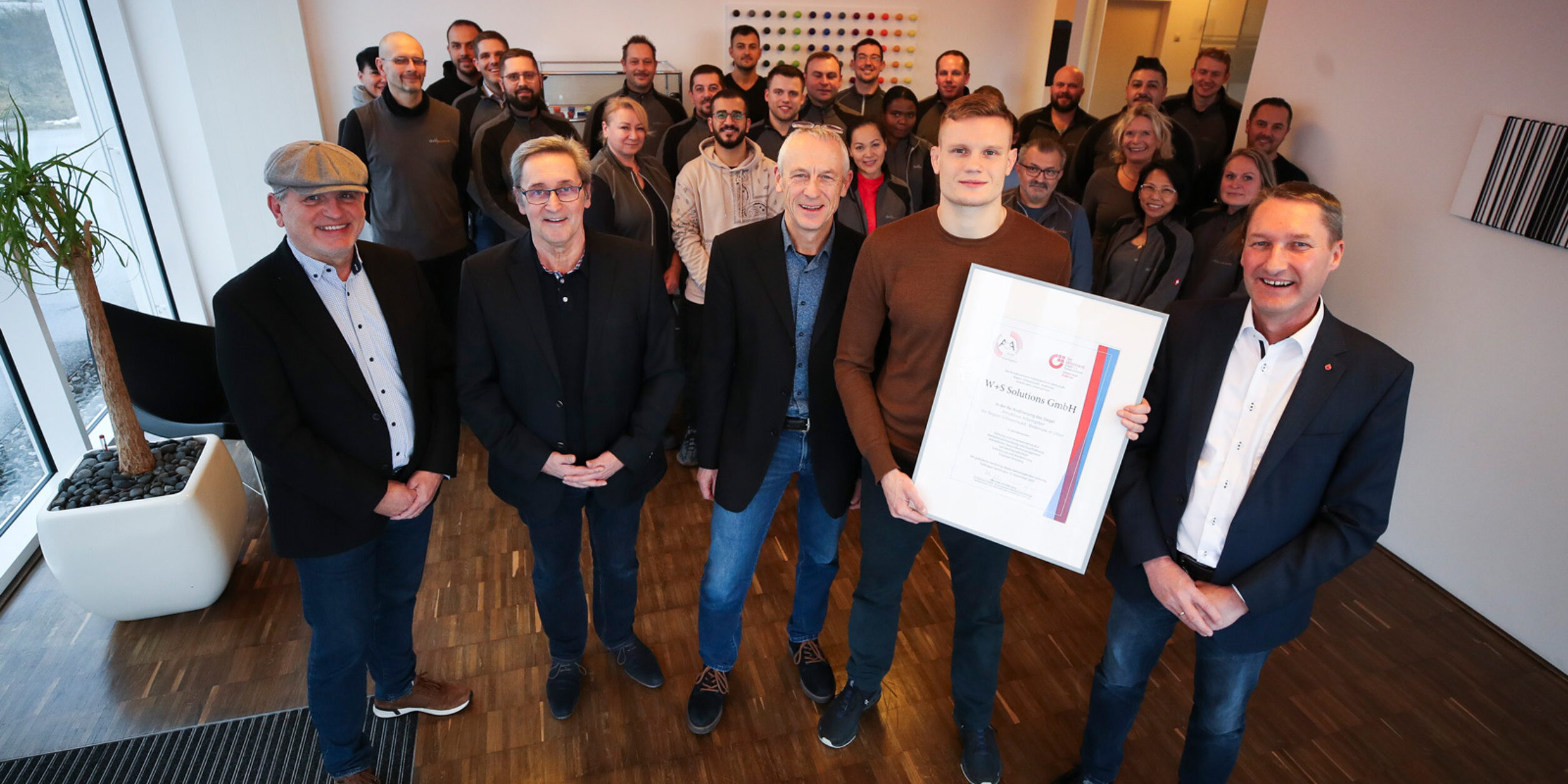 Klaus Zeiler (von links, Leiter der BVMW-Wirtschaftsregion Schwarzwald-Bodensee), Auditor Hugo Frey, die Geschäftsführer Ulrich und Jonathan Wernz sowie Volker Goerz (Leiter des BVMW-Kreisverband Rottweil und Schwarzwald-Baar-Kreis) freuen sich mit den Mitarbeitern über das silberne Siegel „Attraktiver Arbeitgeber“ für W+S Solutions. Foto: BVMW