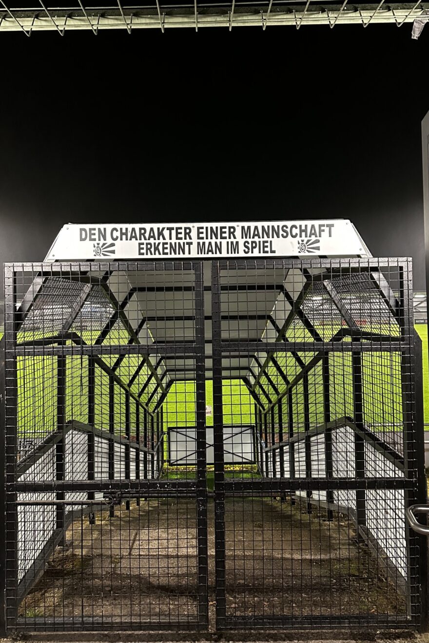 Einlauftor zum Stadion des FC 08 Villingen mit dem Schriftzug "Den Charakter einer Mannschaft erkennt man im Spiel"