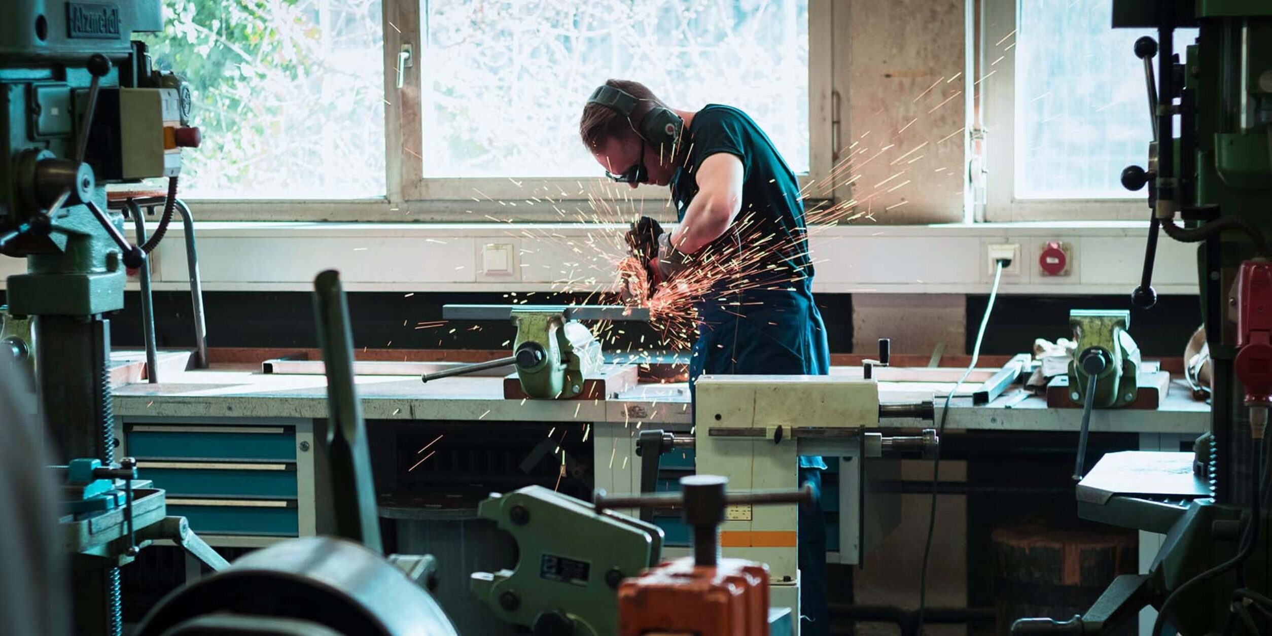 Arbeiter mit Flex in einer Werkstatt