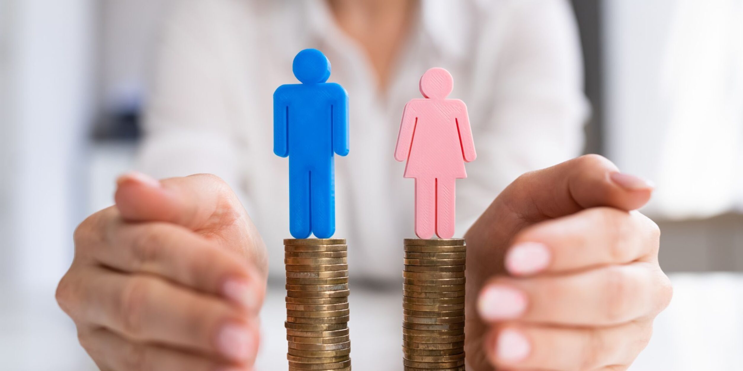Je ein Symbol für Mann und für Frau stehen auf einem gleichhohen Münzstapel