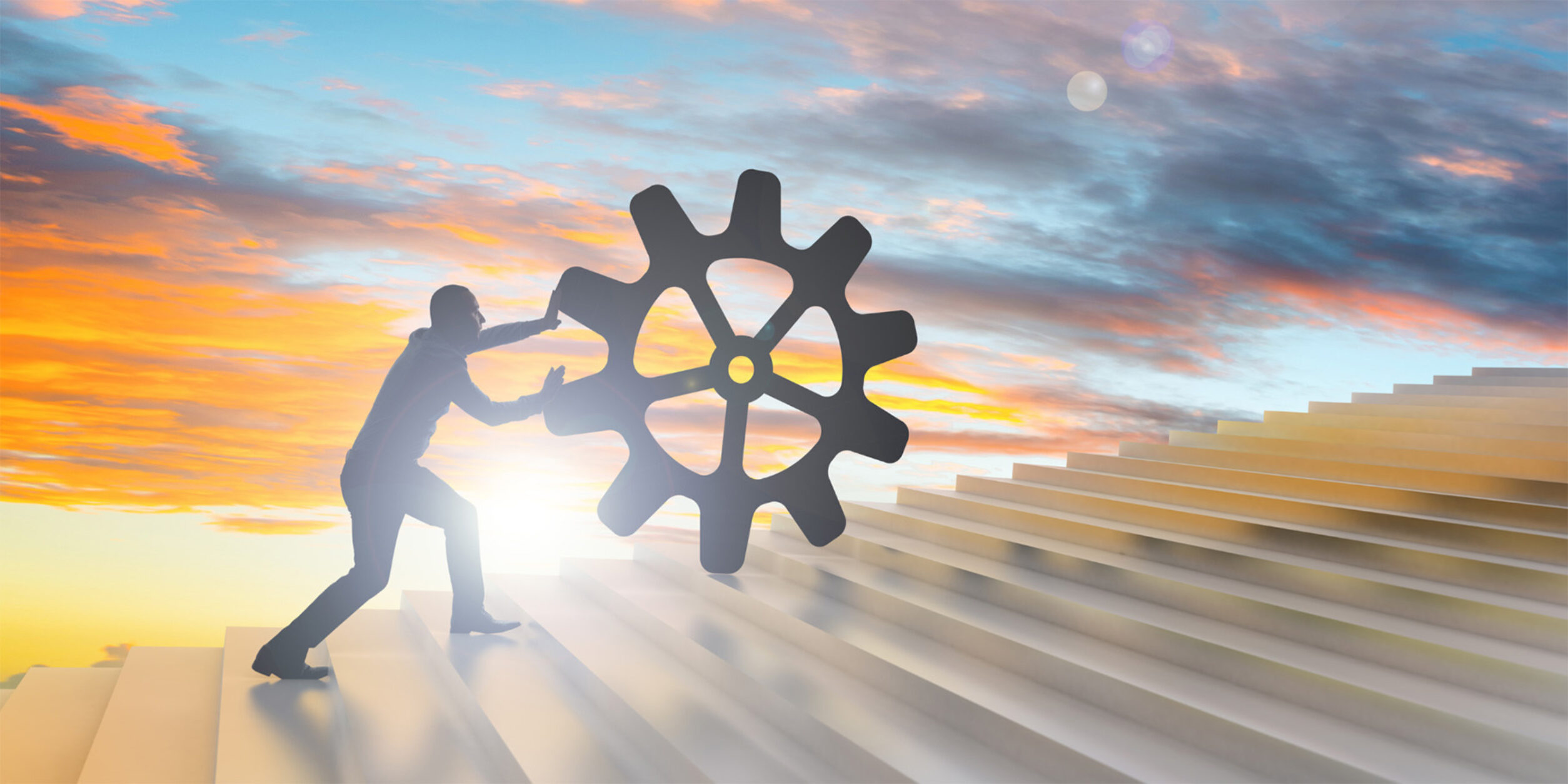 Mann rollt Zahnrad Treppe hinauf