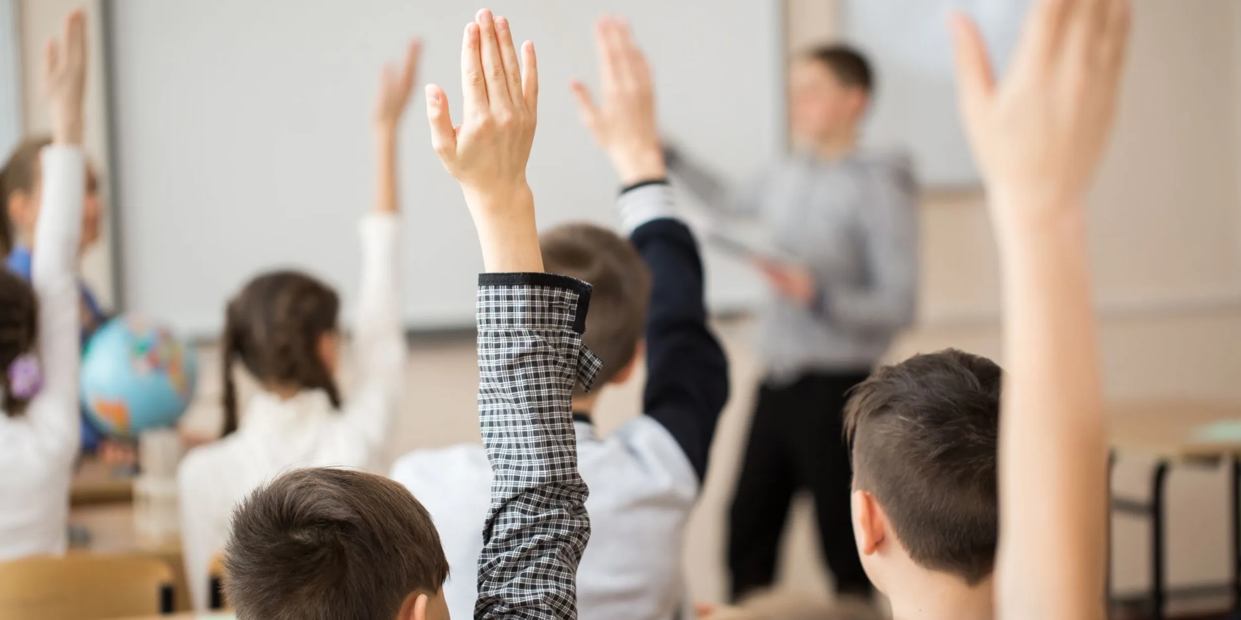 Kinder melden sich im Klassenzimmer