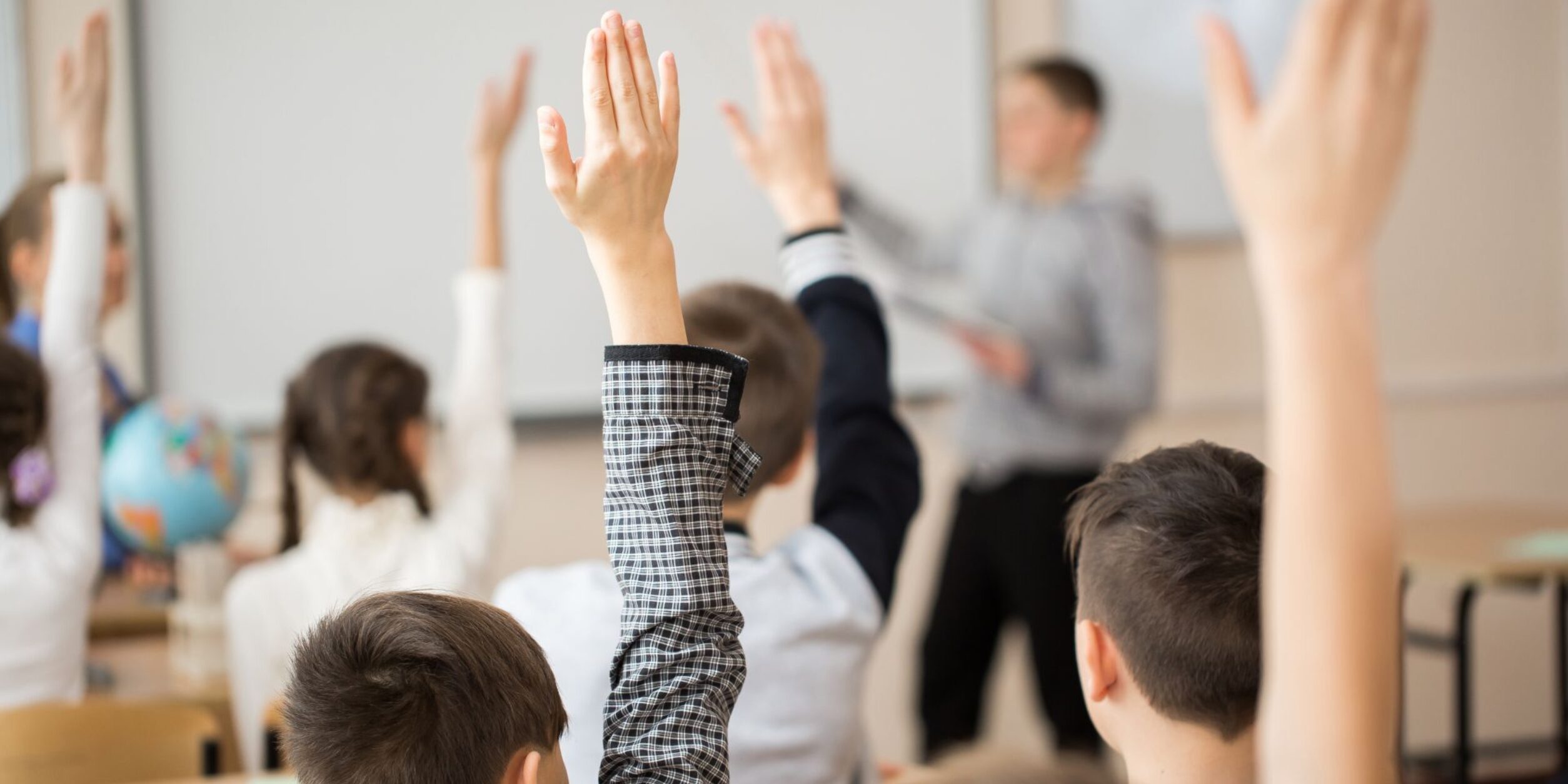 Kinder melden sich im Klassenzimmer