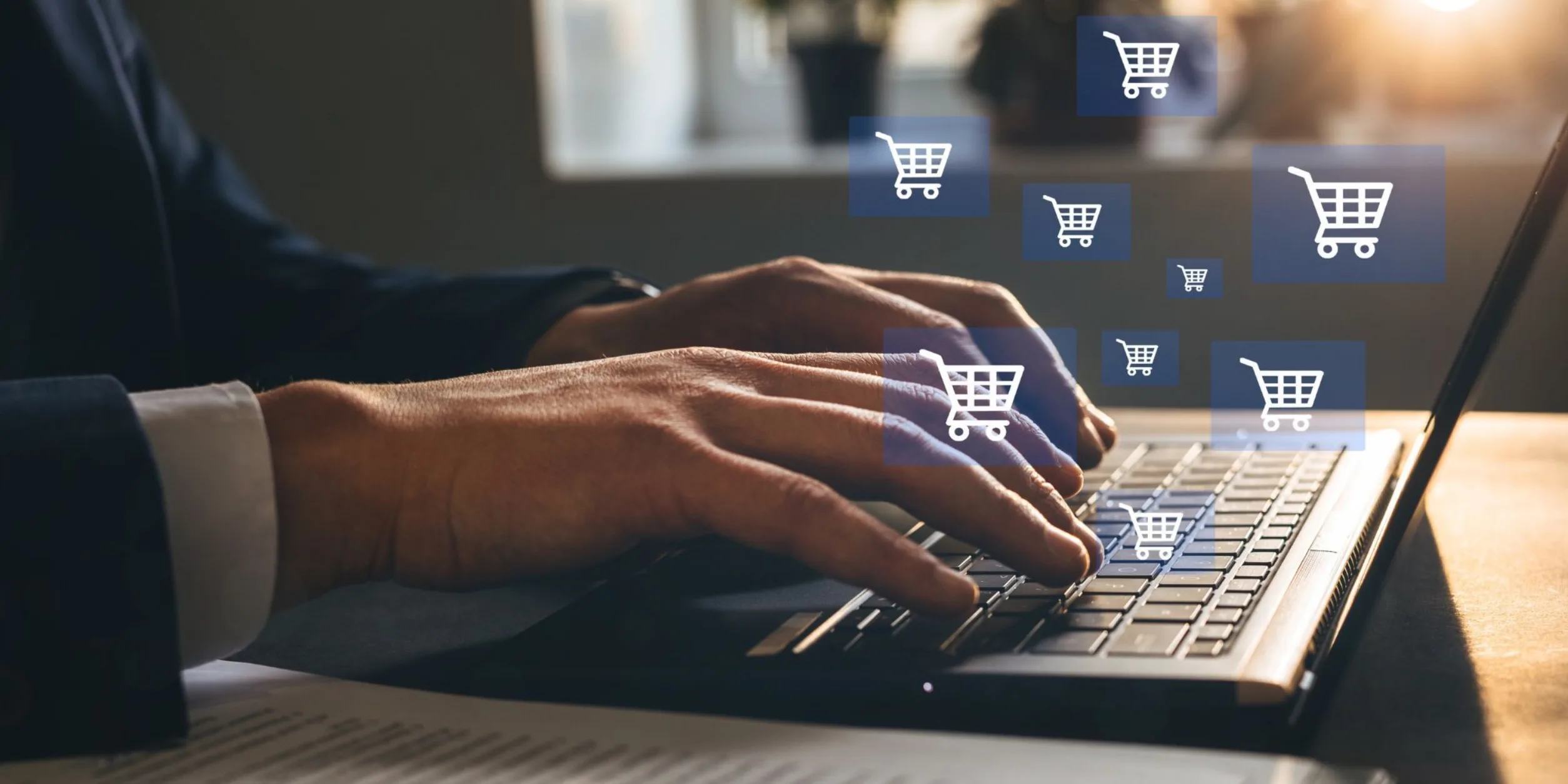 Ein Mann benutzt die Tastatur eines Laptops aus dem virtuelle Kästchen mit Warenkörbe kommen