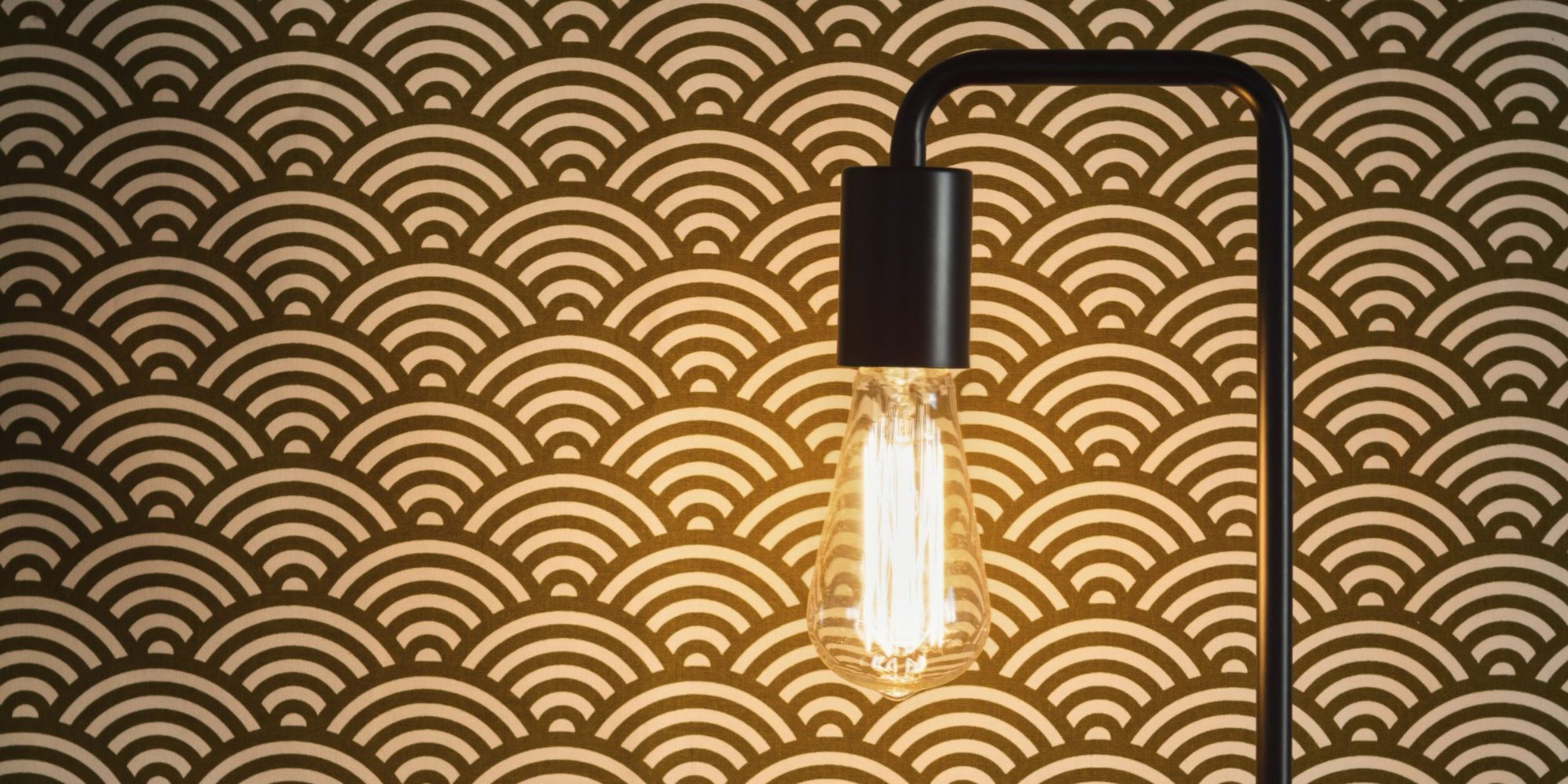 Eine Lampe vor einer Designertapete