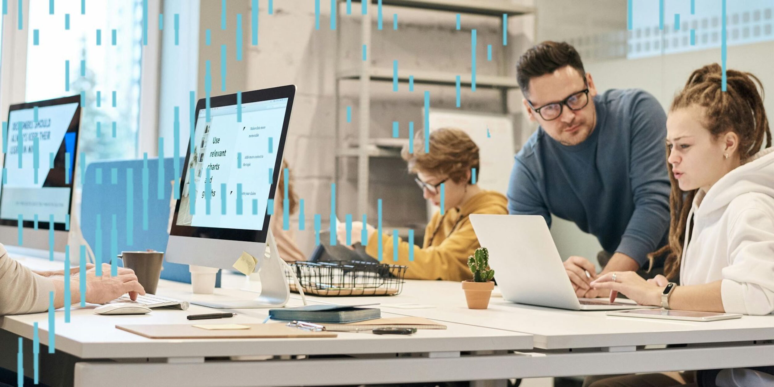 Zwei Junge Personen schauen in einem Büro gemeinsam auf einen Laptop