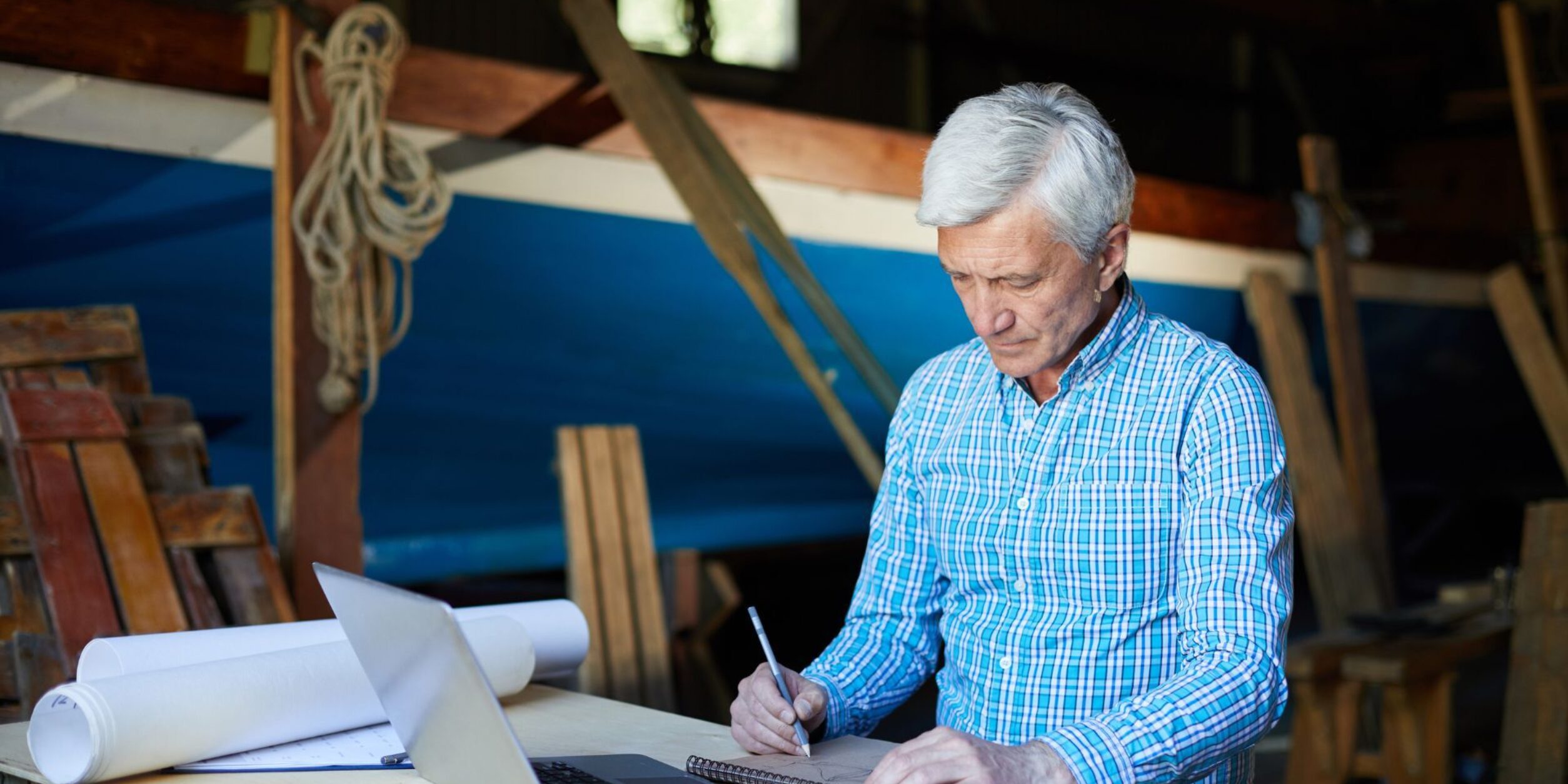 Ein älterer Unternehmer schreibt etwas auf einem Block