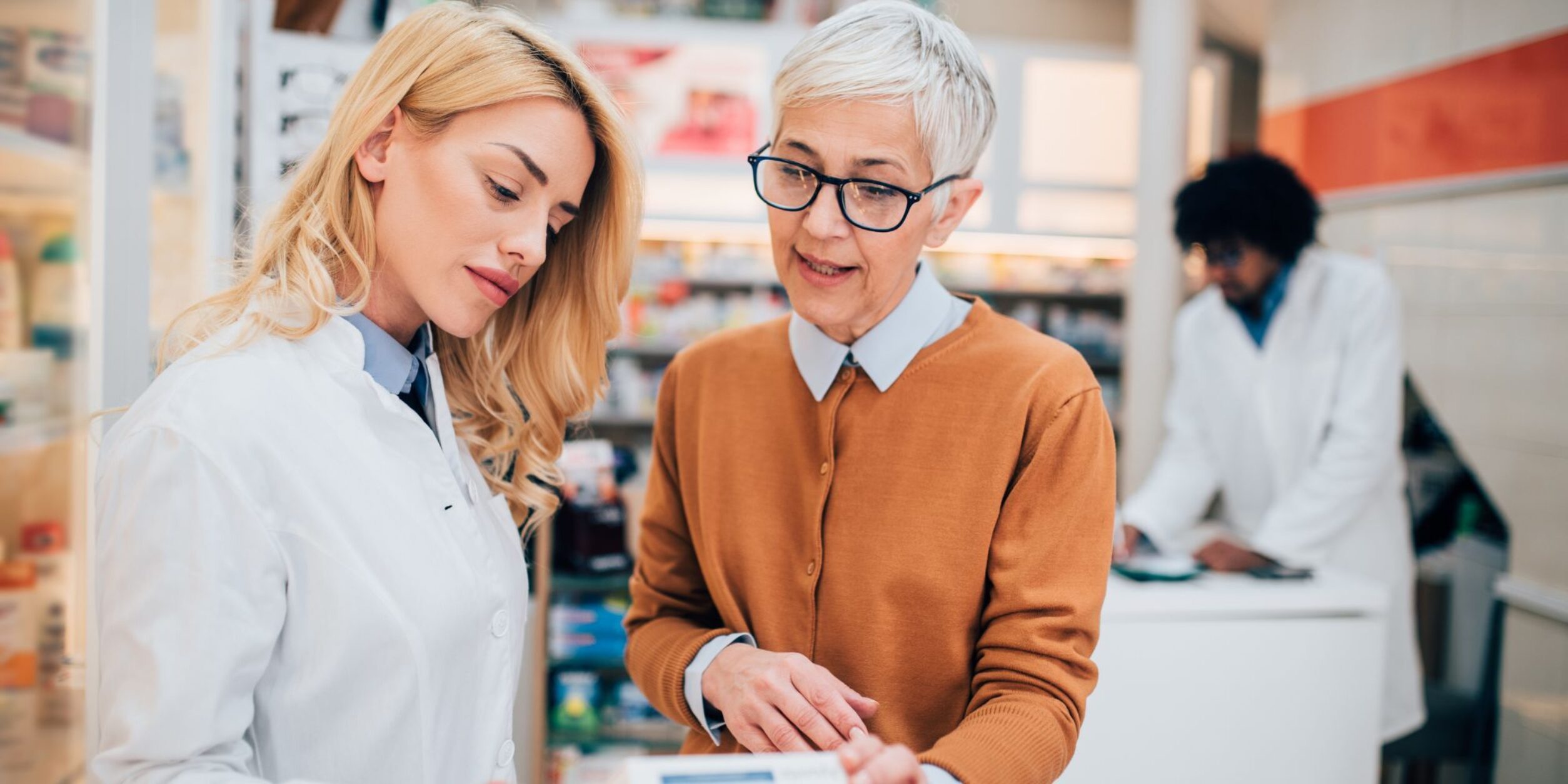 Eine ältere Unternehmerin erklärt etwas einer jüngeren Mitarbeiterin