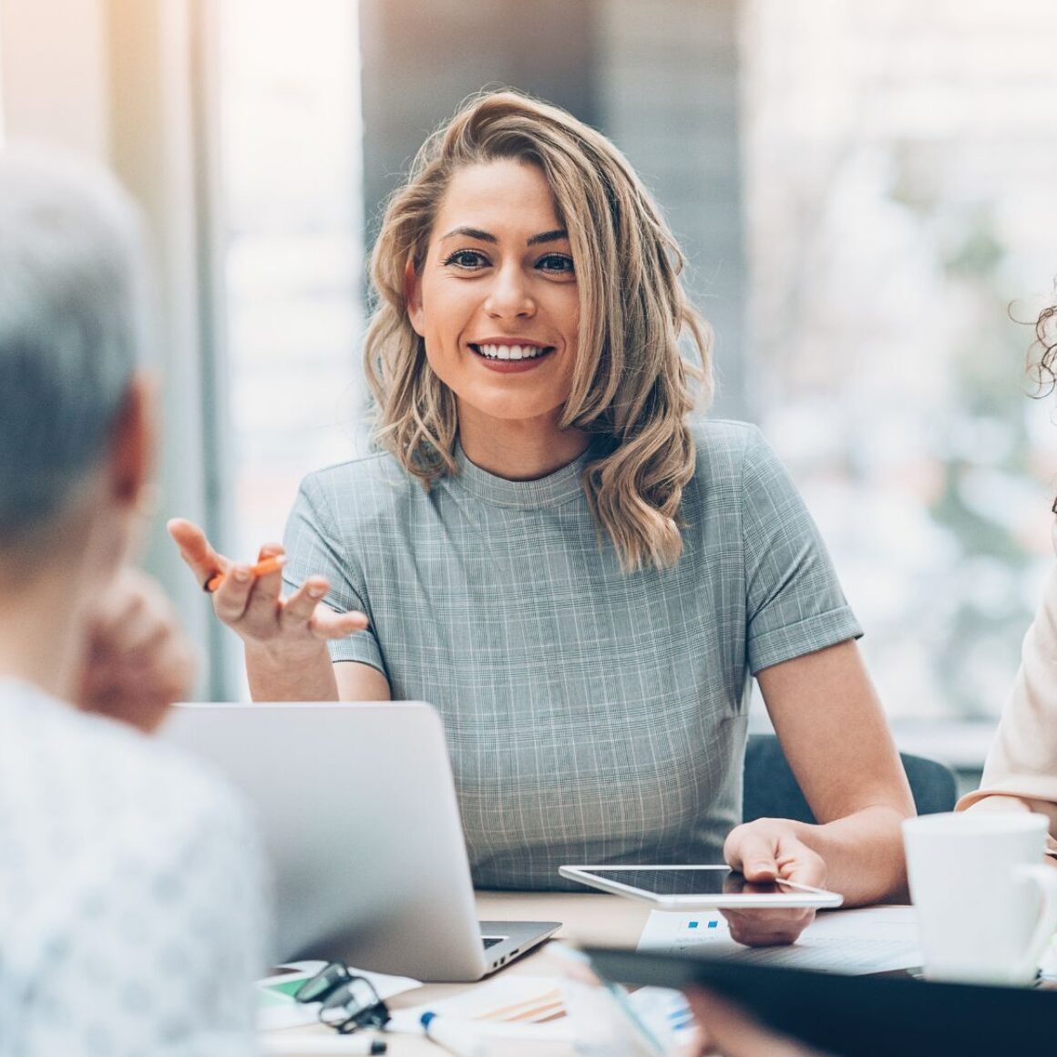 Eine weibliche Geschäftsführerin spricht in die Runde