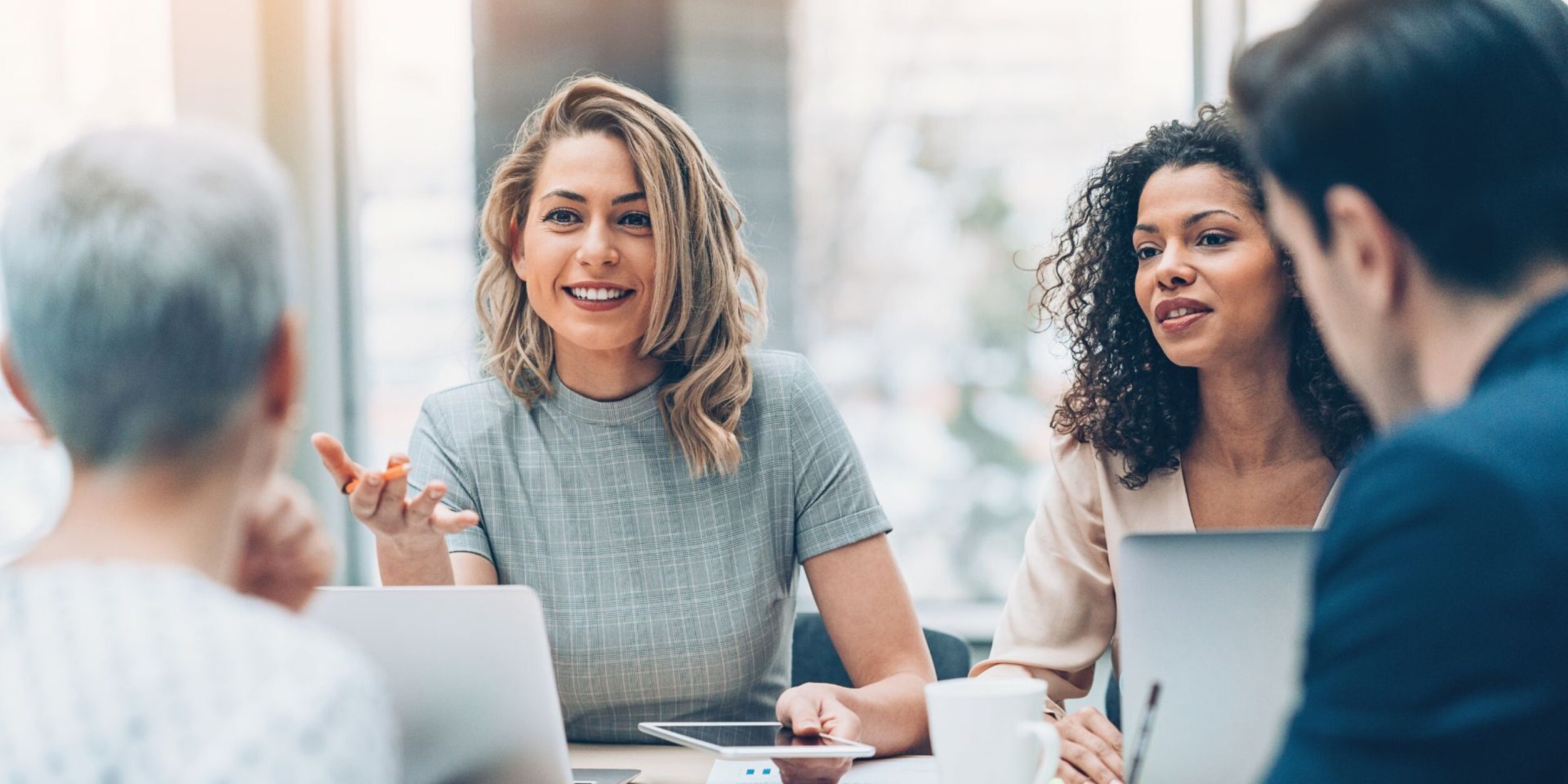 Eine weibliche Geschäftsführerin spricht in die Runde